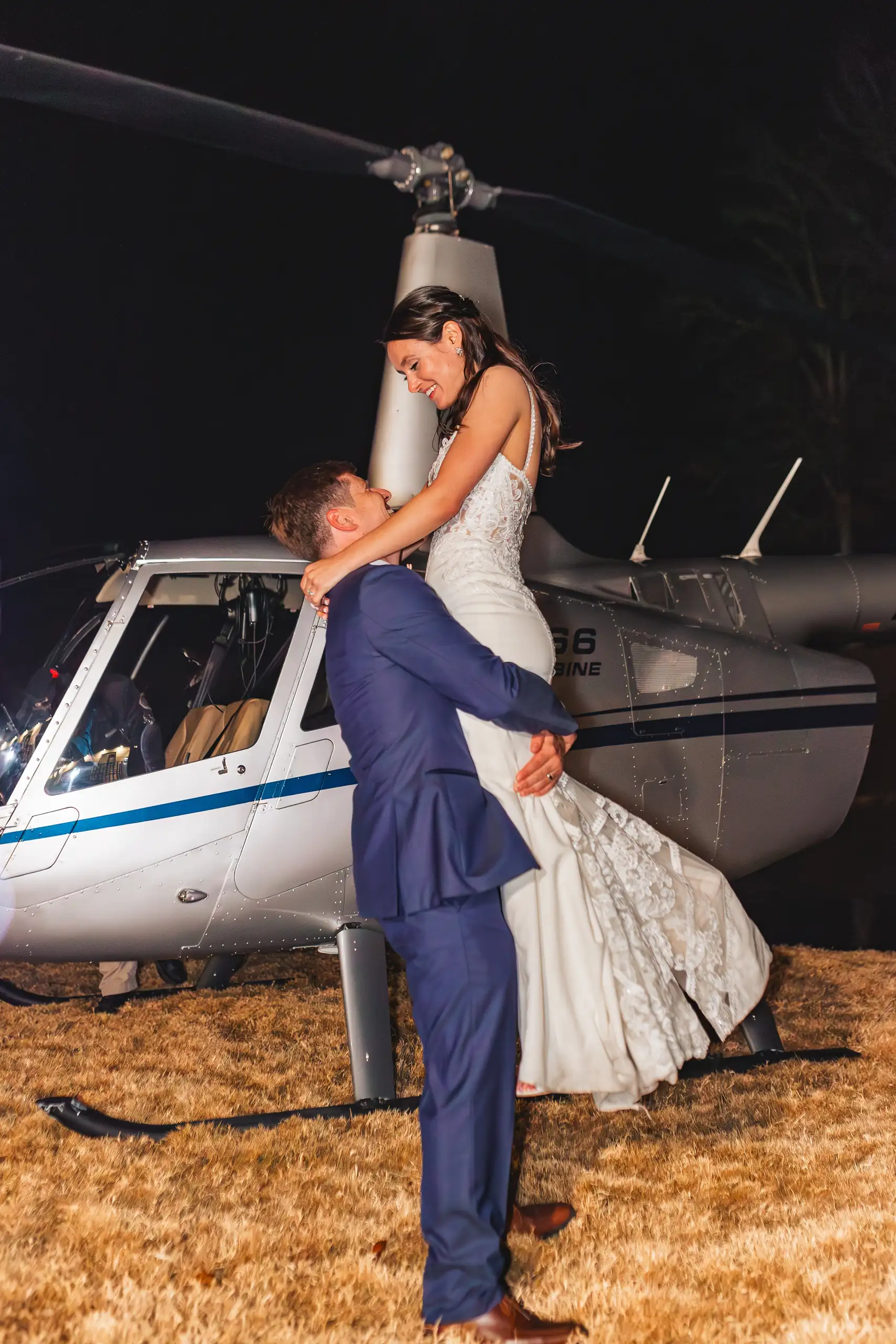Send-Off: the couple kissing under the helicopter rotor, at their wedding at Swan Lake Overlook in Dawsonville, GA