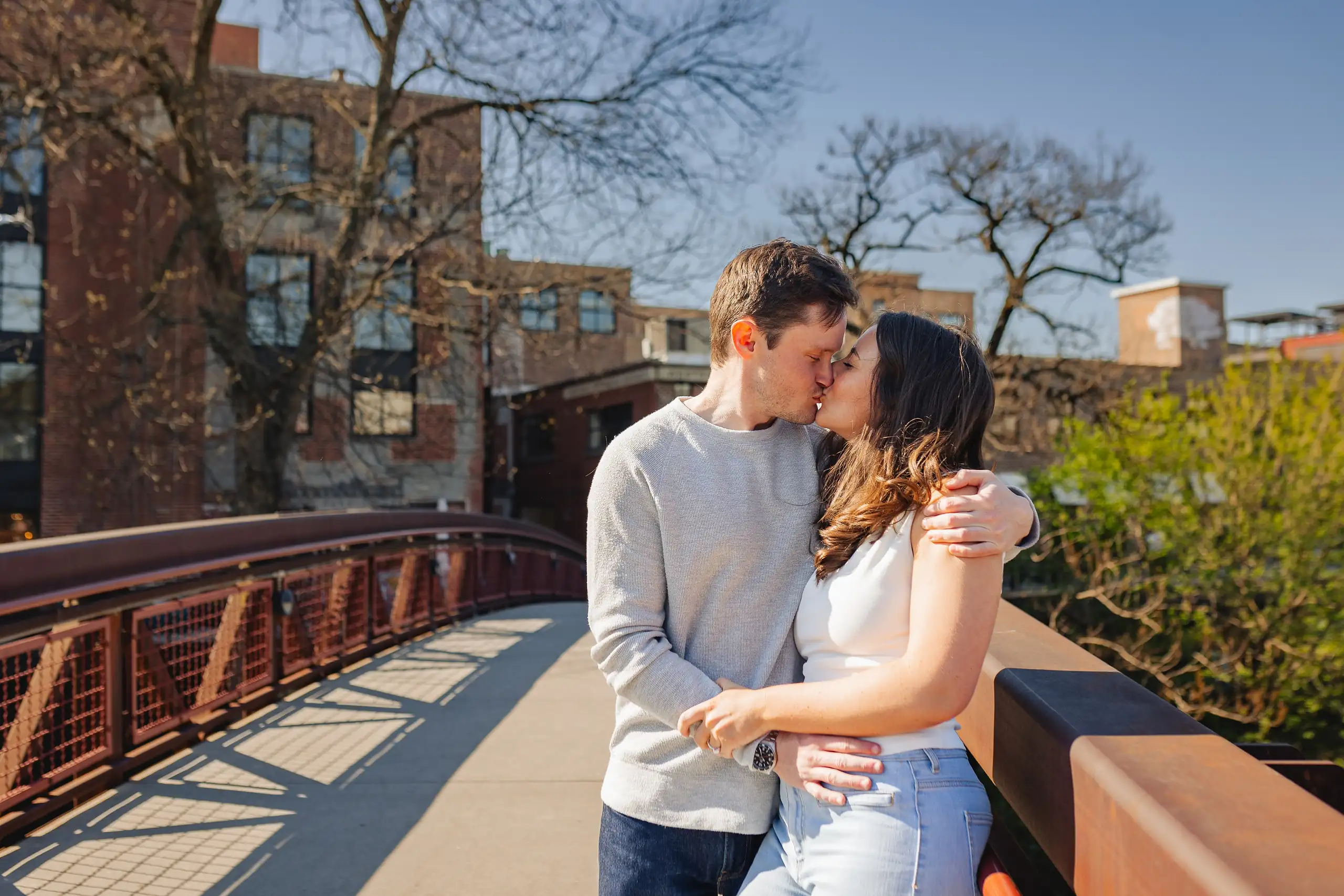Engagement Portraits: the couple close together on the orange footbridge, during their engagement session at Westside Provisions in Atlanta, GA