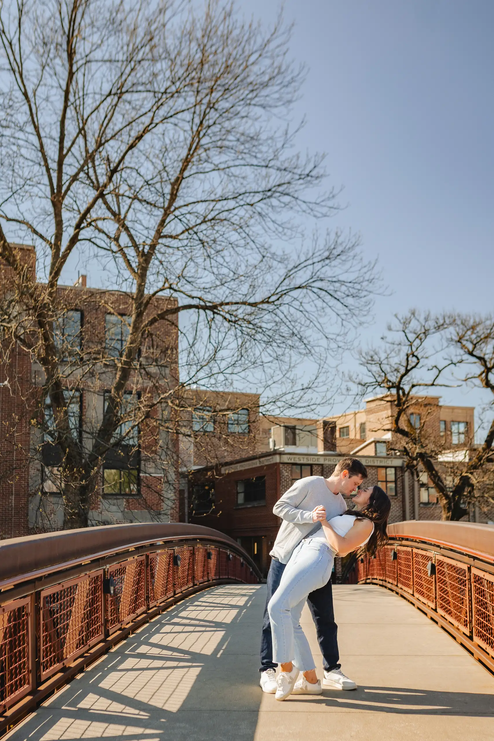 Engagement Portraits: the groom-to-be dipping her on the bridge, during their engagement session at Westside Provisions in Atlanta, GA