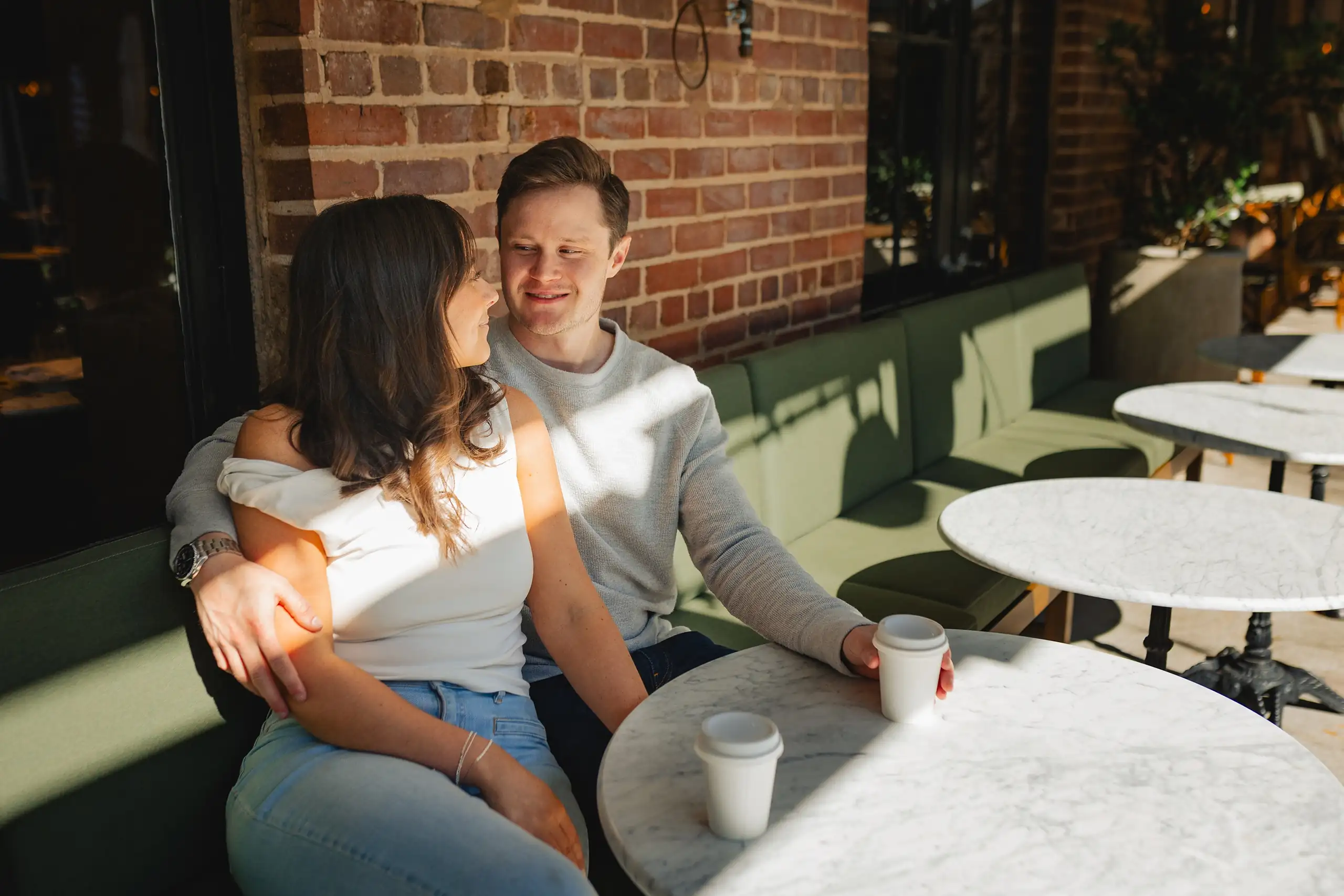 Engagement Portraits: the two of them at a coffee table on the patio, during their engagement session at Westside Provisions in Atlanta, GA