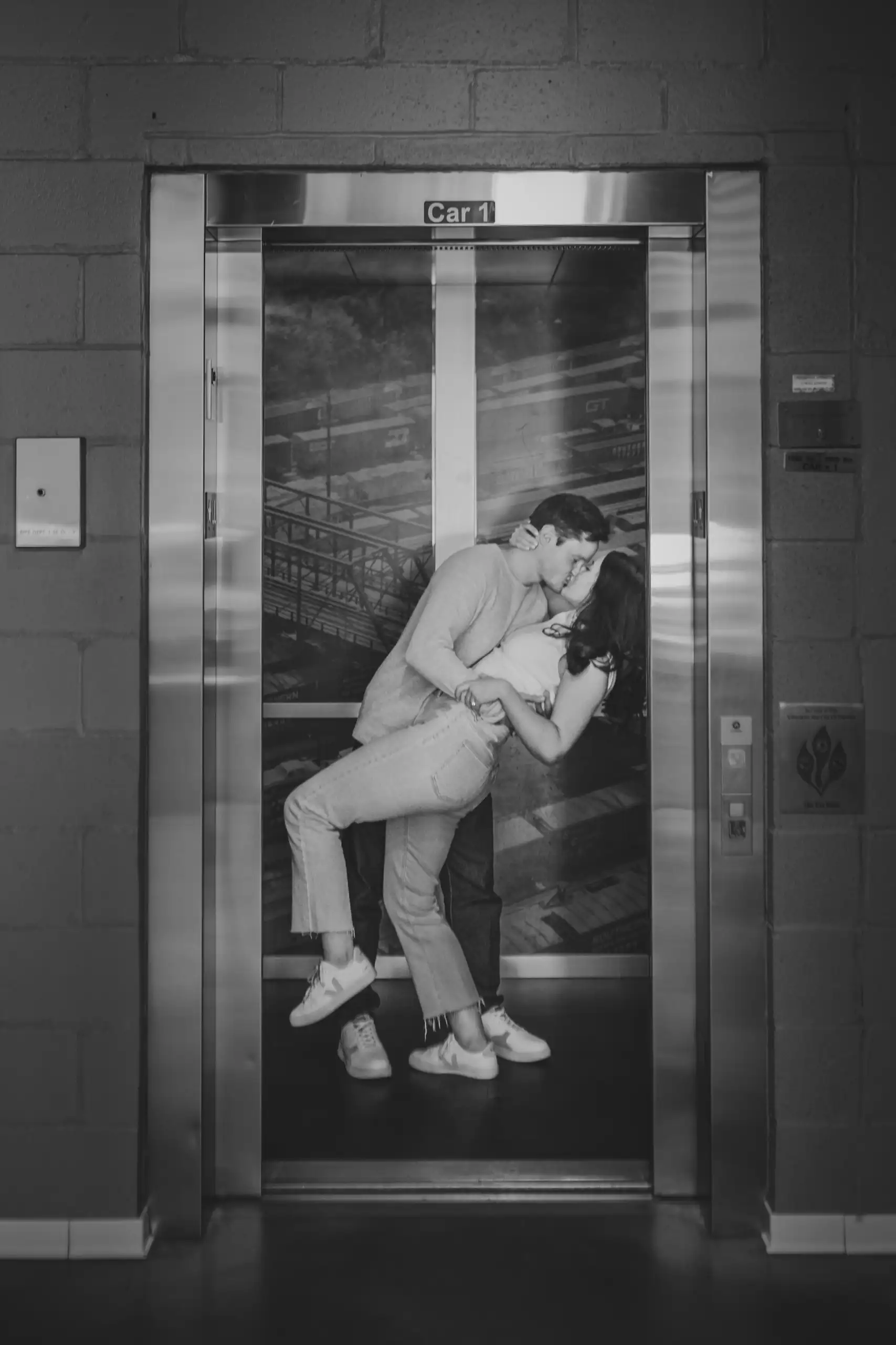 Engagement Portraits: a kiss in the freight elevator, in black and white, during their engagement session at Westside Provisions in Atlanta, GA