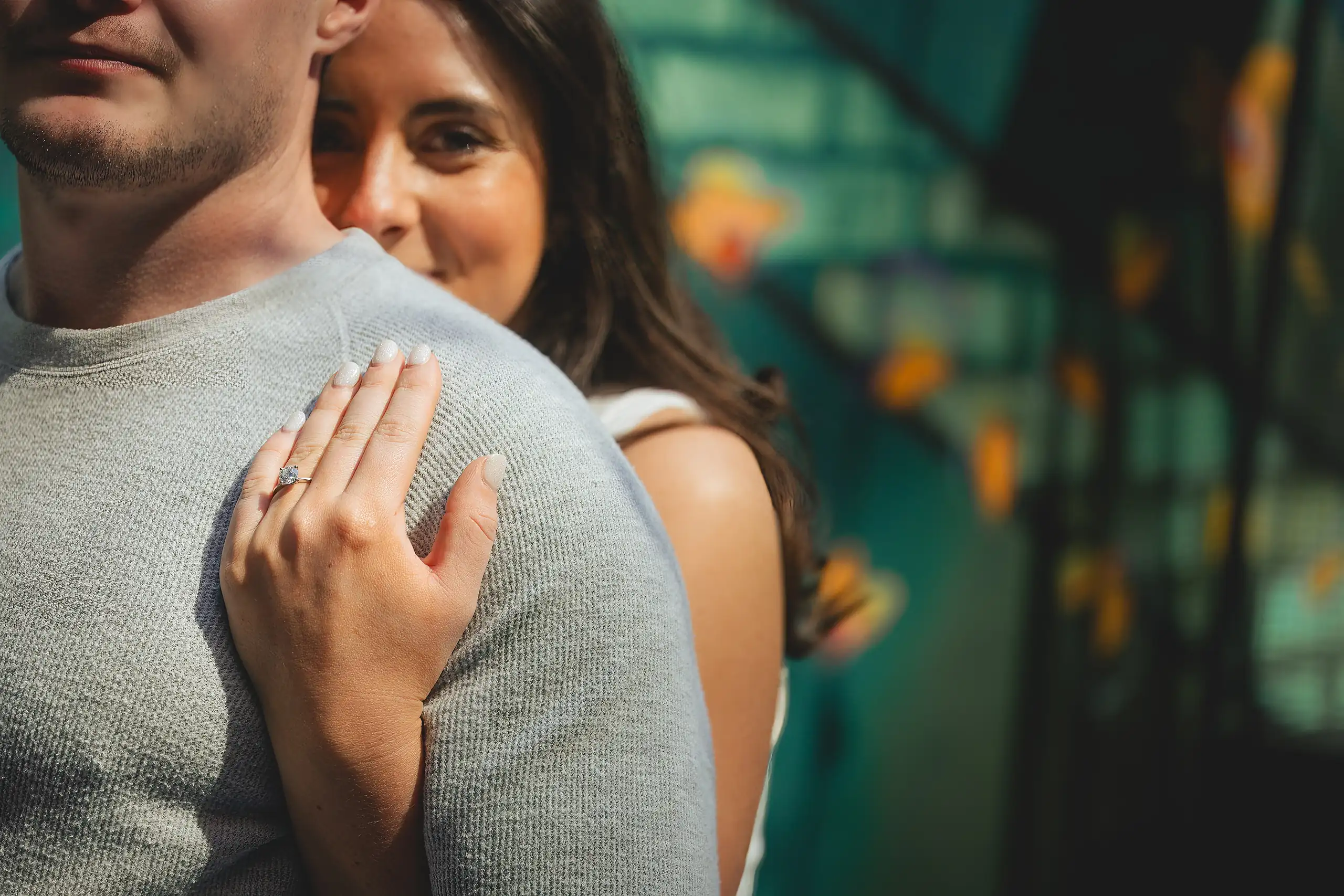 Engagement Portraits: her ring hand resting on his shoulder, during their engagement session at Westside Provisions in Atlanta, GA