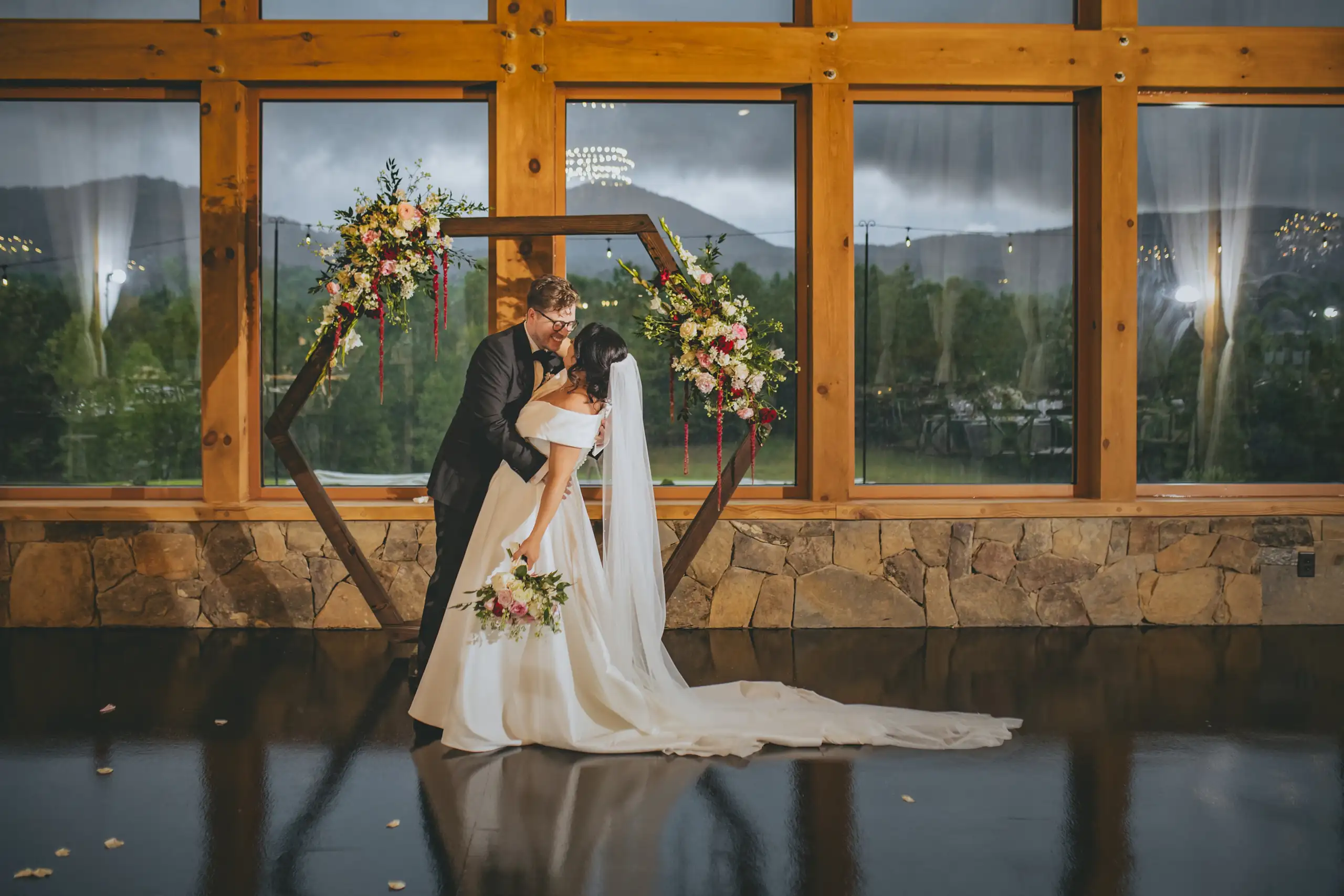 Wedding Formals: the two of them at the hexagon arch, reflected in the water, at their wedding at The Venue at Sharp Mountain in Jasper, GA