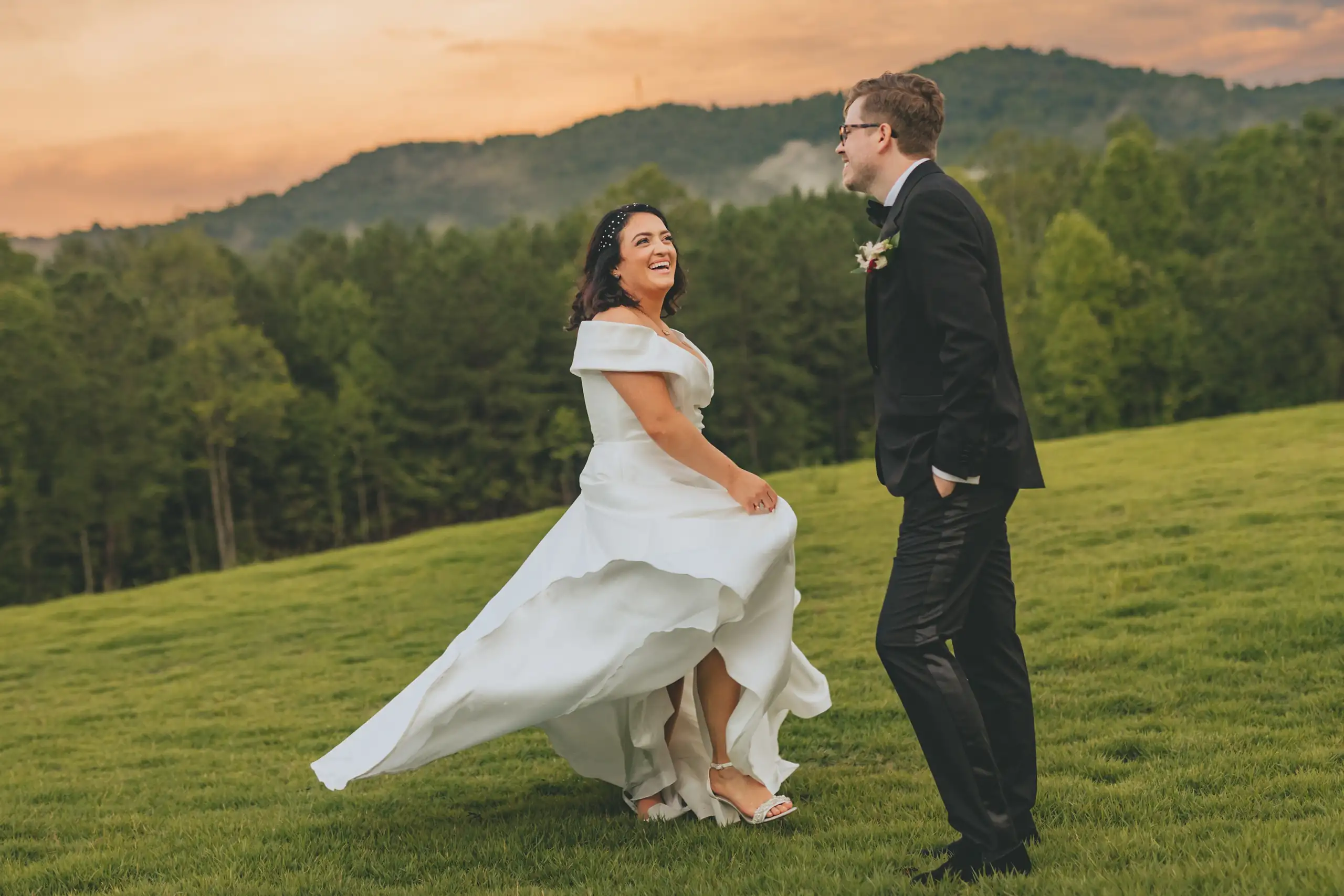Wedding Formals: the couple on the lawn as the sun drops behind the hills, at their wedding at The Venue at Sharp Mountain in Jasper, GA