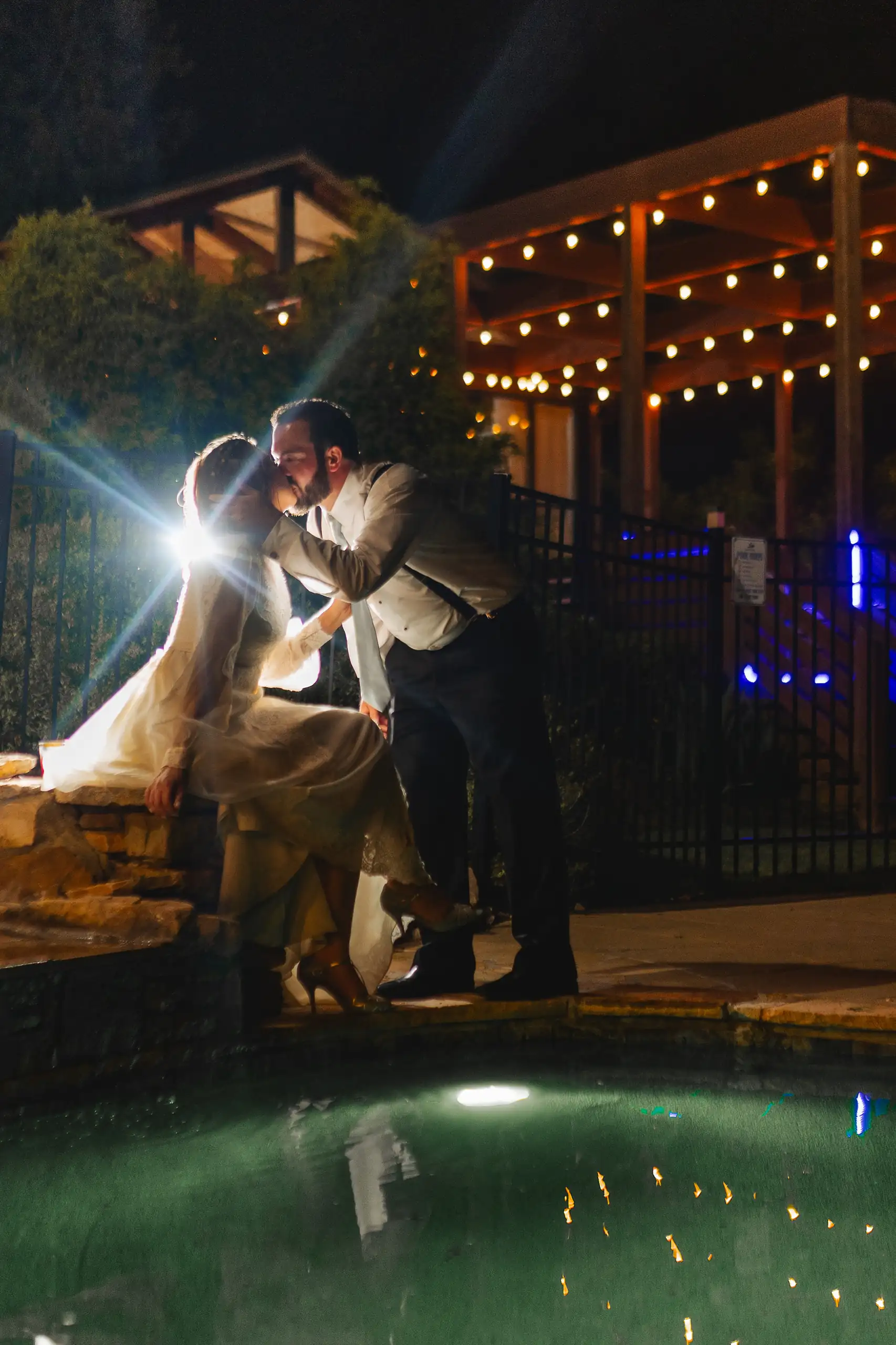Wedding Reception: the couple lit by sparklers beside the pool at night, at their wedding at Three Birches in Alpharetta, GA