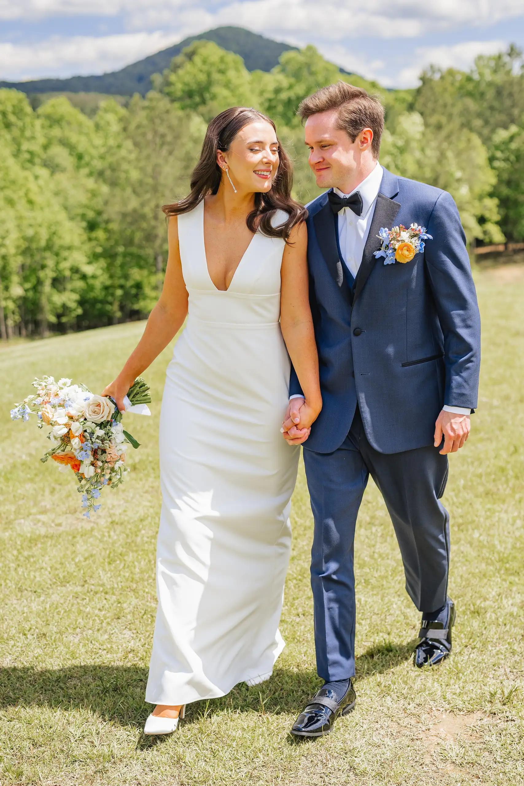 Wedding Formals: the couple walking the lawn with her bouquet, at their wedding at The Venue at Sharp Mountain in Jasper, GA