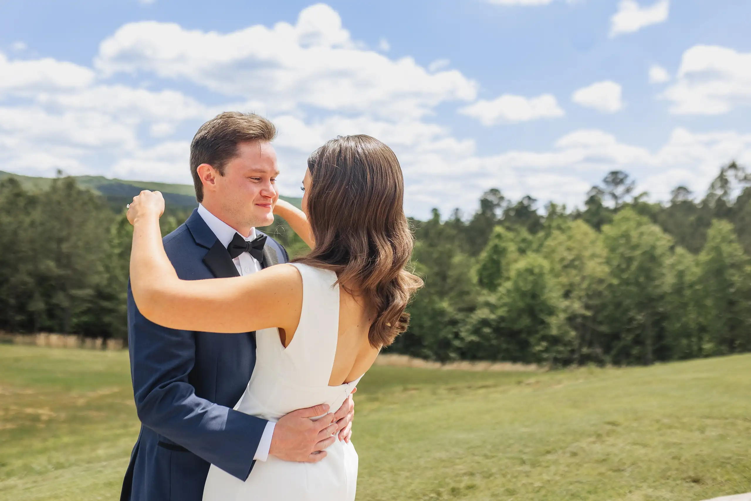 First Look: her arms round his neck once he has turned, before their wedding at The Venue at Sharp Mountain in Jasper, GA
