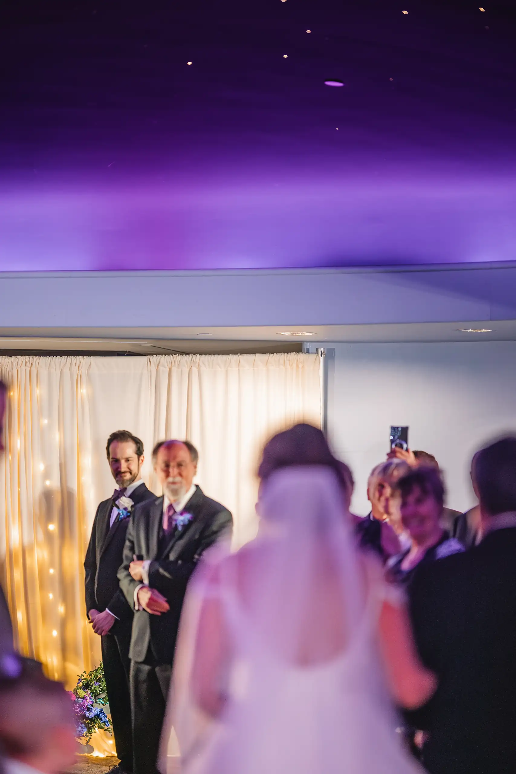 Wedding Ceremony: the couple at the altar under the purple dome, at their wedding at Fernbank Museum in Atlanta, GA
