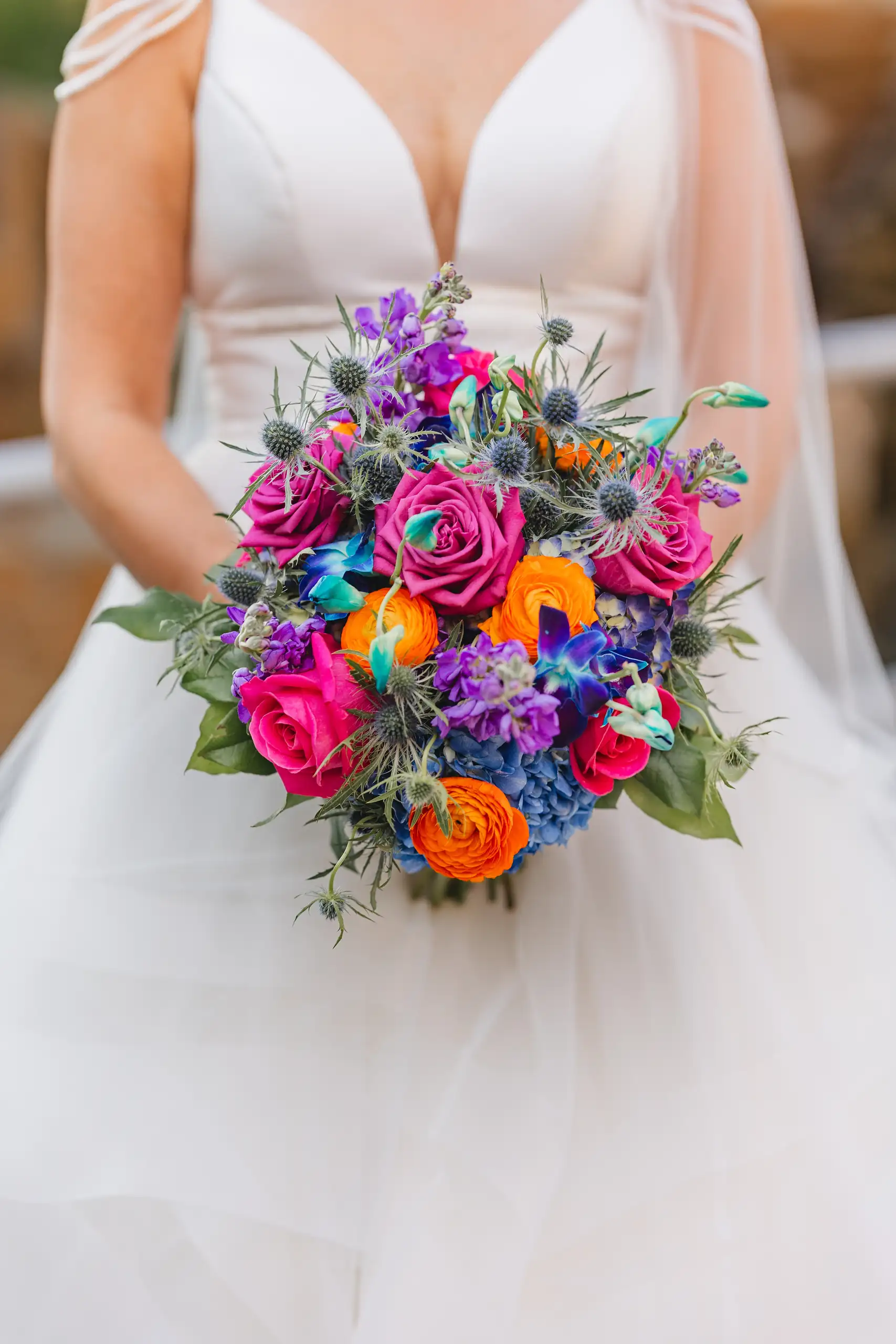 Wedding Florals: her bouquet of purple, blue, pink and orange blooms, at their wedding at Fernbank Museum in Atlanta, GA