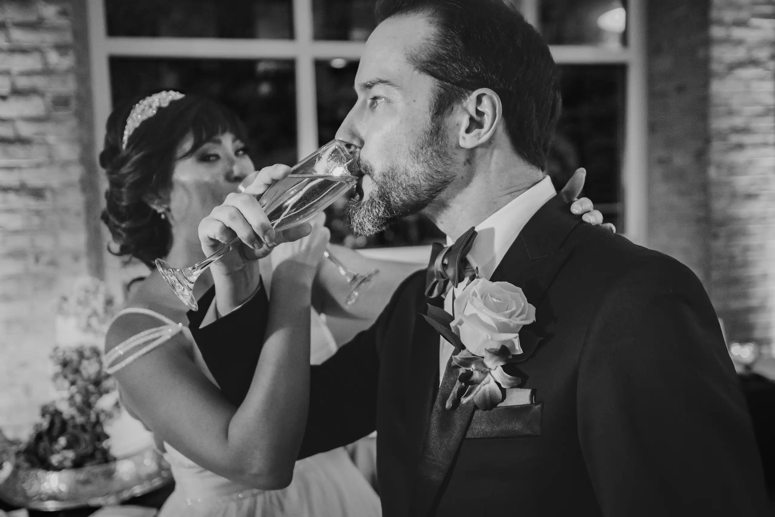 Wedding Reception: the two of them drinking a toast, in black and white, at their wedding at Fernbank Museum in Atlanta, GA