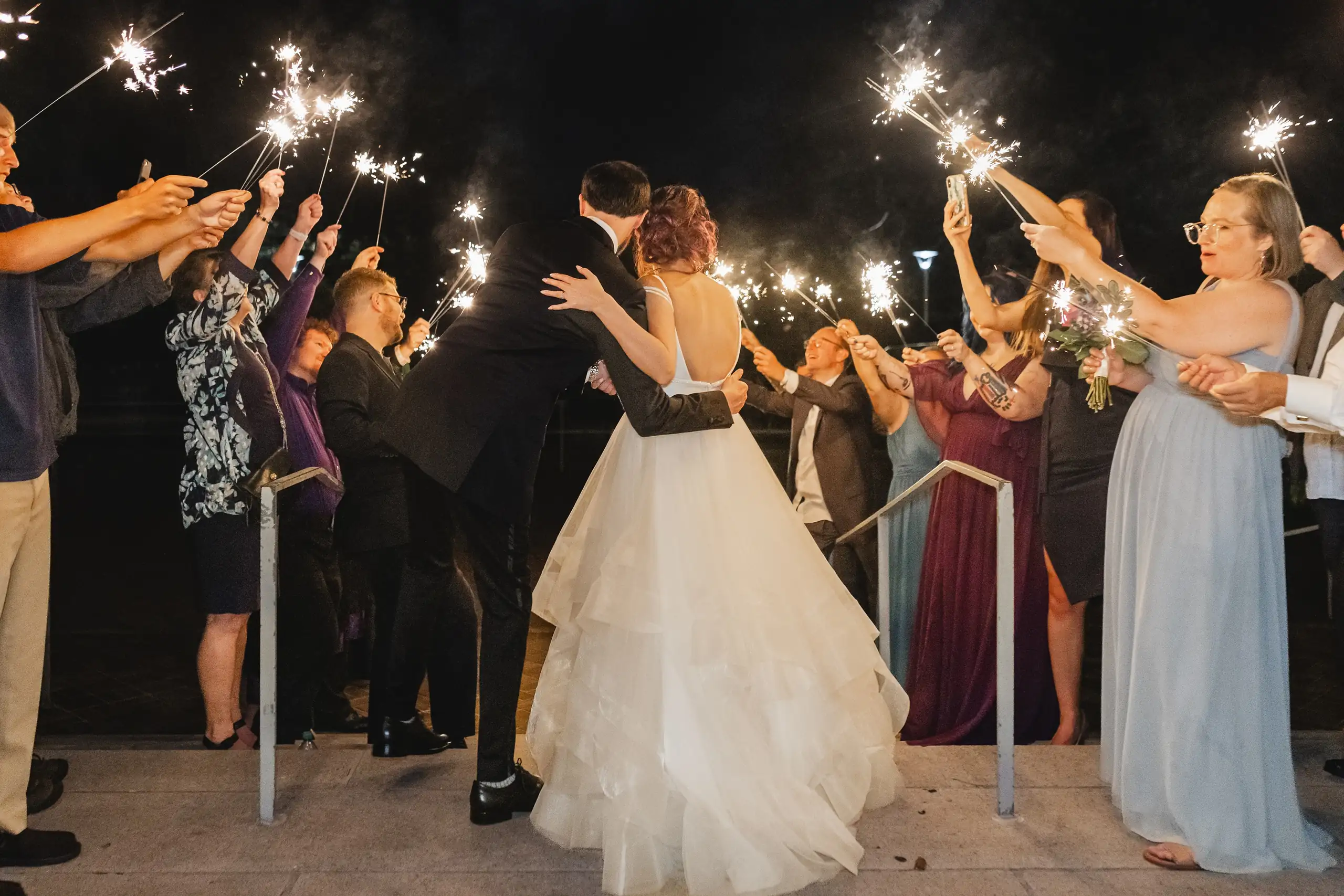 Sparkler Exit: the couple going out through a line of sparklers, at their wedding at Fernbank Museum in Atlanta, GA