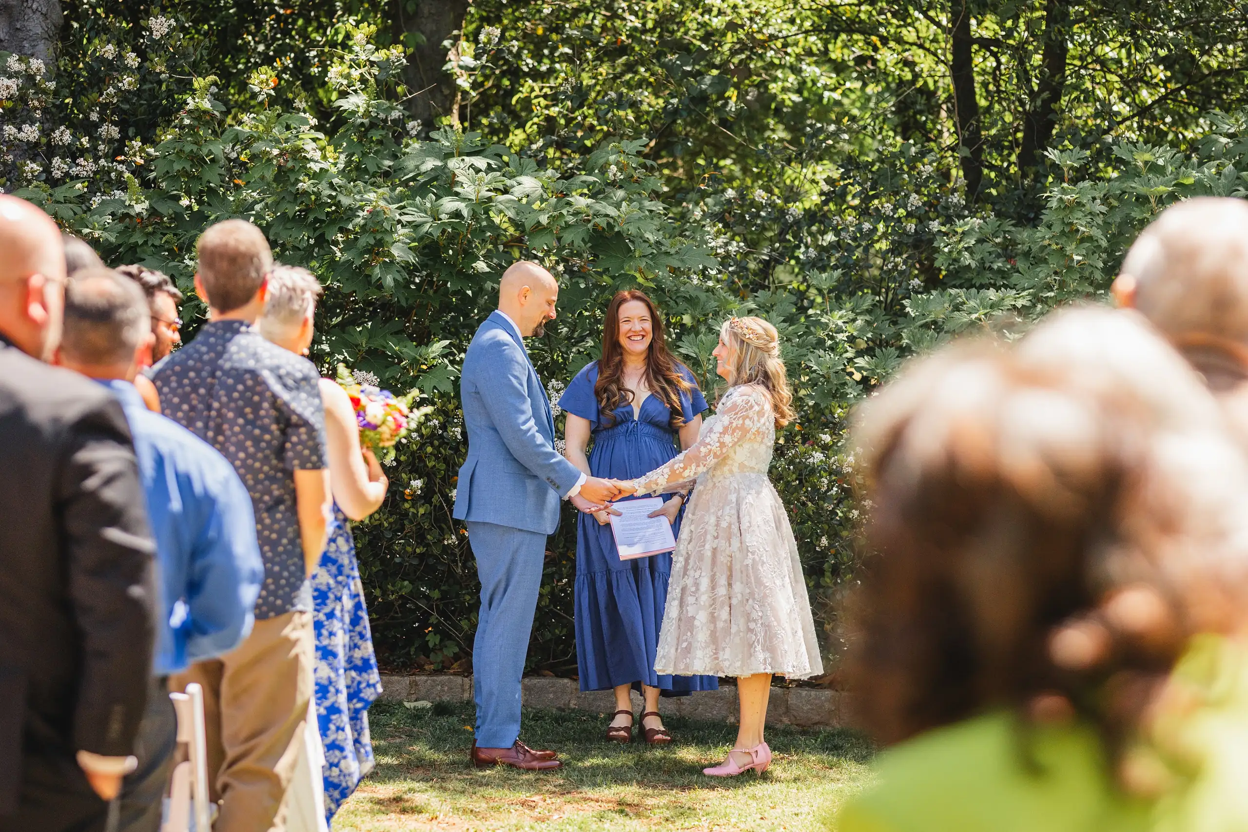 Wedding Ceremony: the officiant reading, guests close around, at their wedding at Callanwolde Fine Arts Center in Atlanta, GA