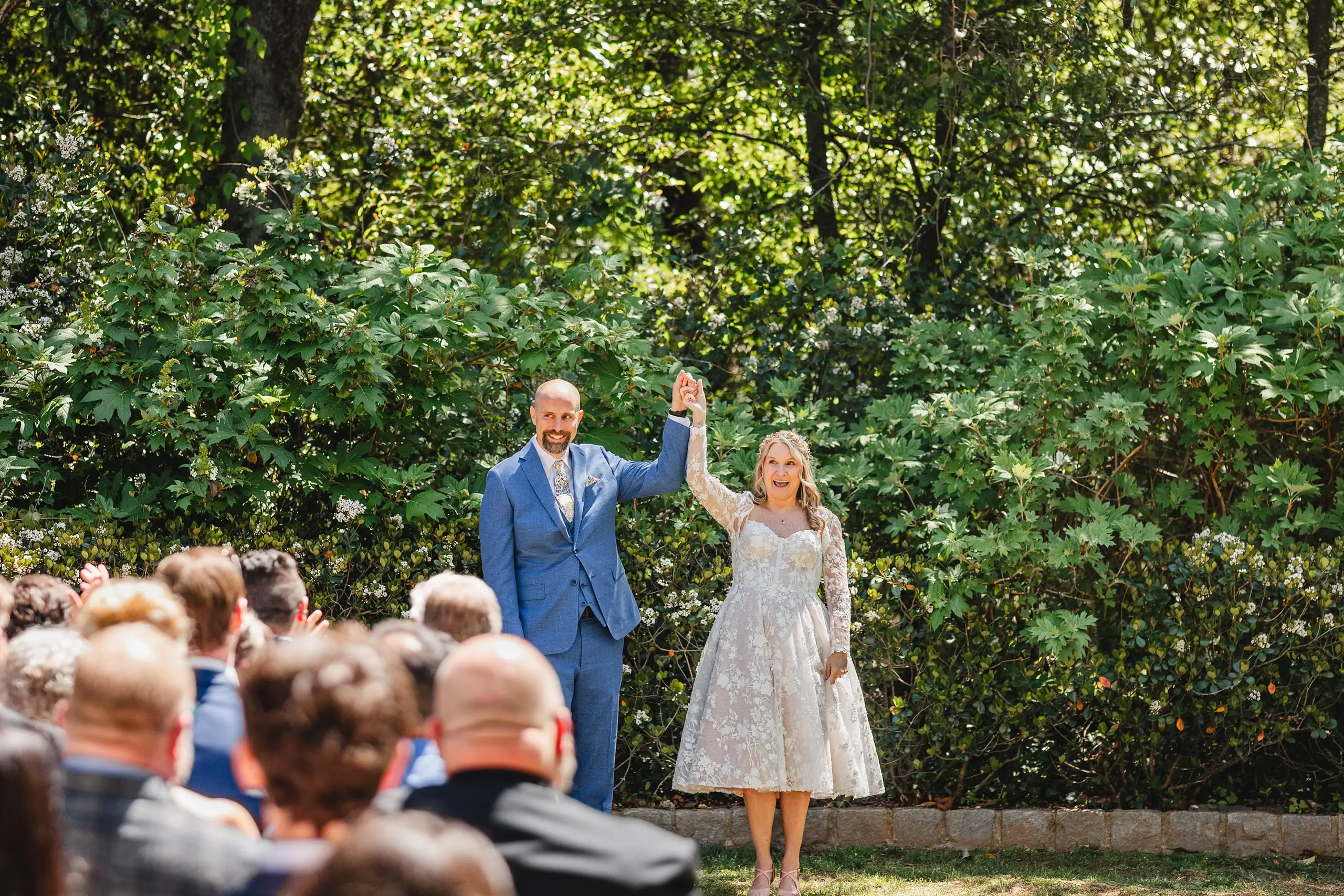 Wedding Ceremony: the couple celebrating with their hands raised, at their wedding at Callanwolde Fine Arts Center in Atlanta, GA
