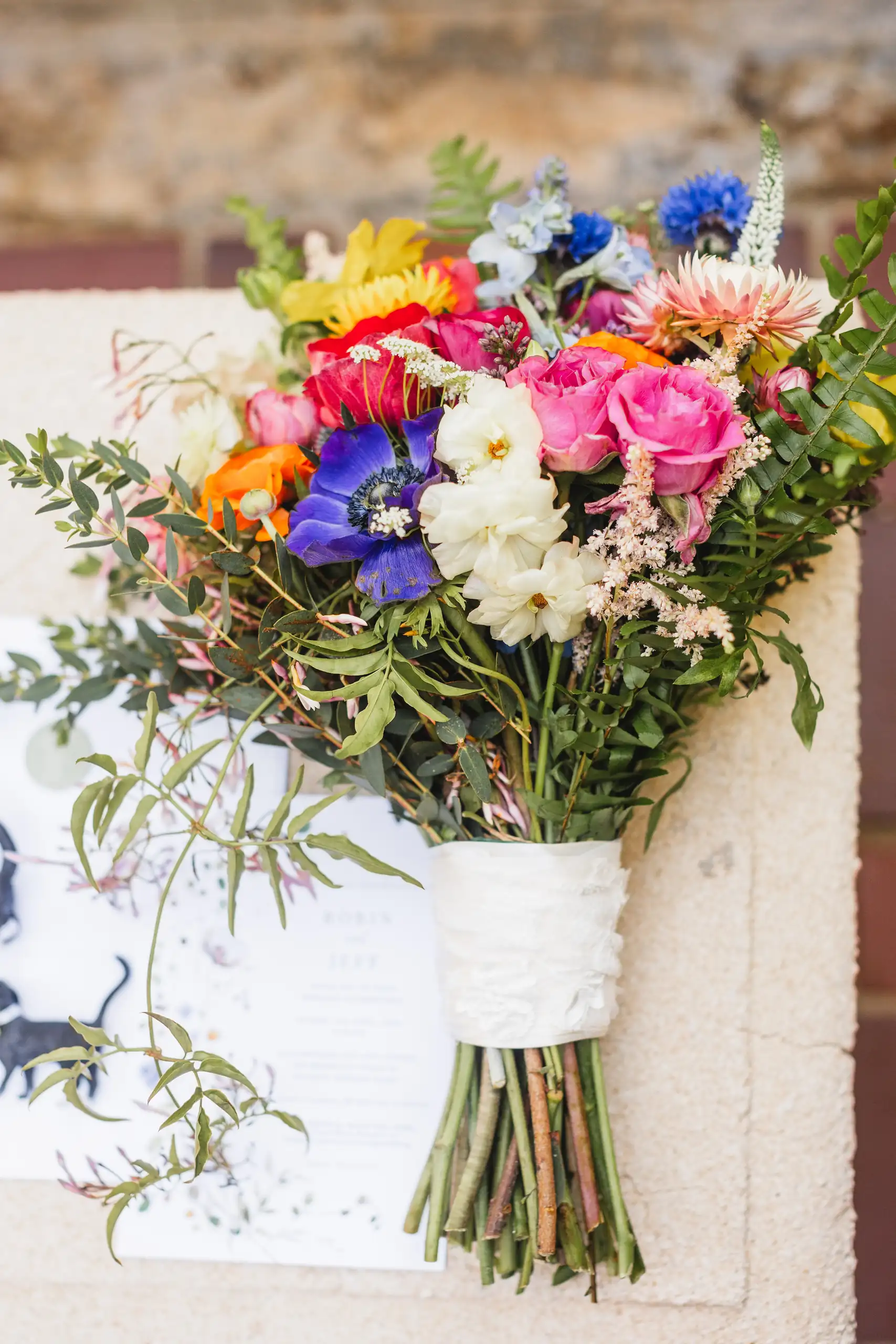 Wedding Florals: the wildflower bouquet resting on the invitation, at a wedding at Callanwolde Fine Arts Center in Atlanta, GA