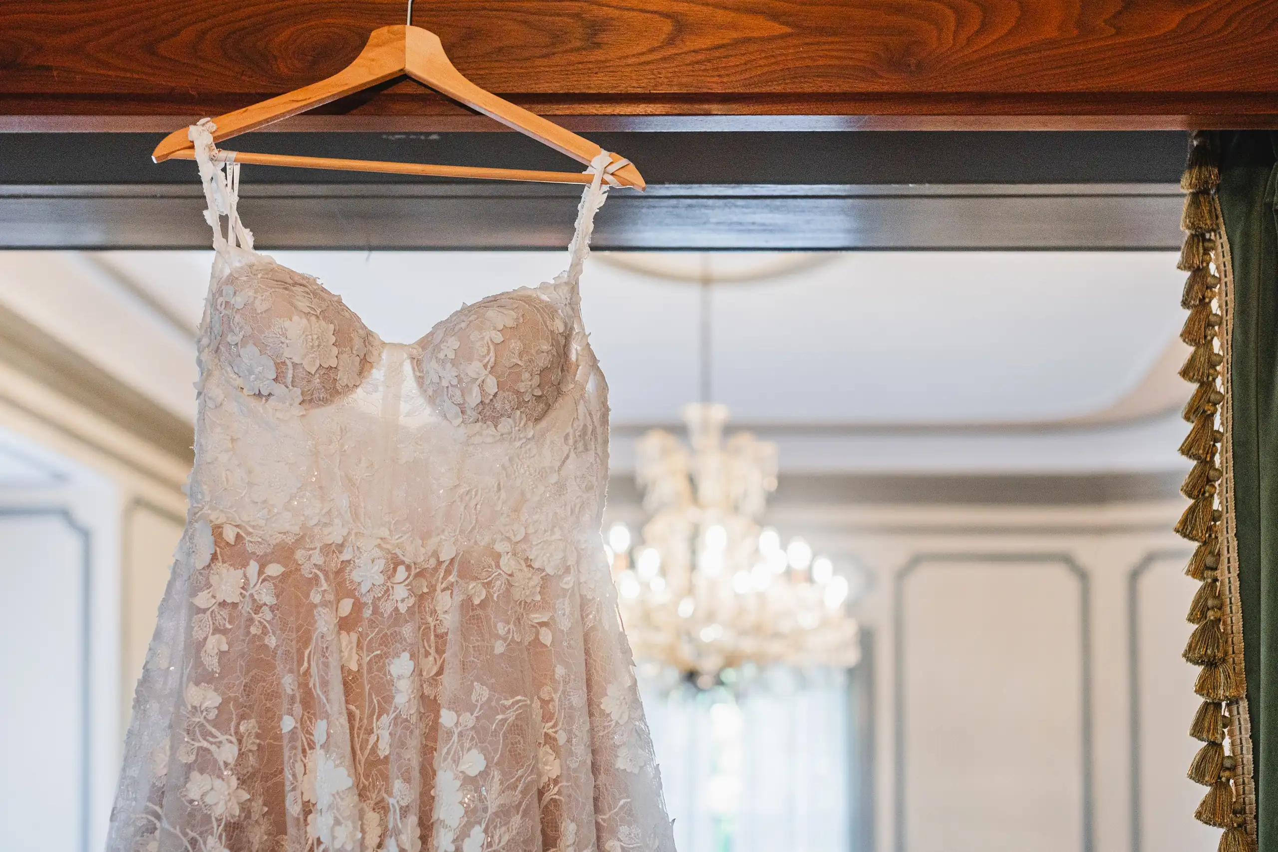 Wedding Details: the lace gown hanging beneath a chandelier, at a wedding at Callanwolde Fine Arts Center in Atlanta, GA