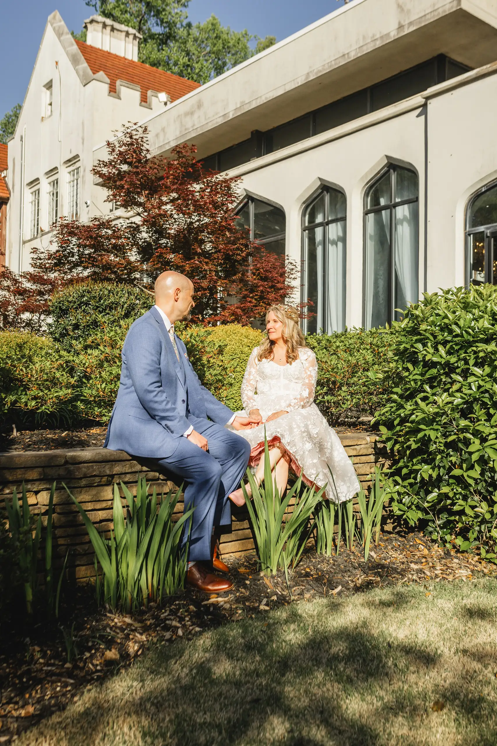 Wedding Formals: the couple sitting on a garden wall, at their wedding at Callanwolde Fine Arts Center in Atlanta, GA