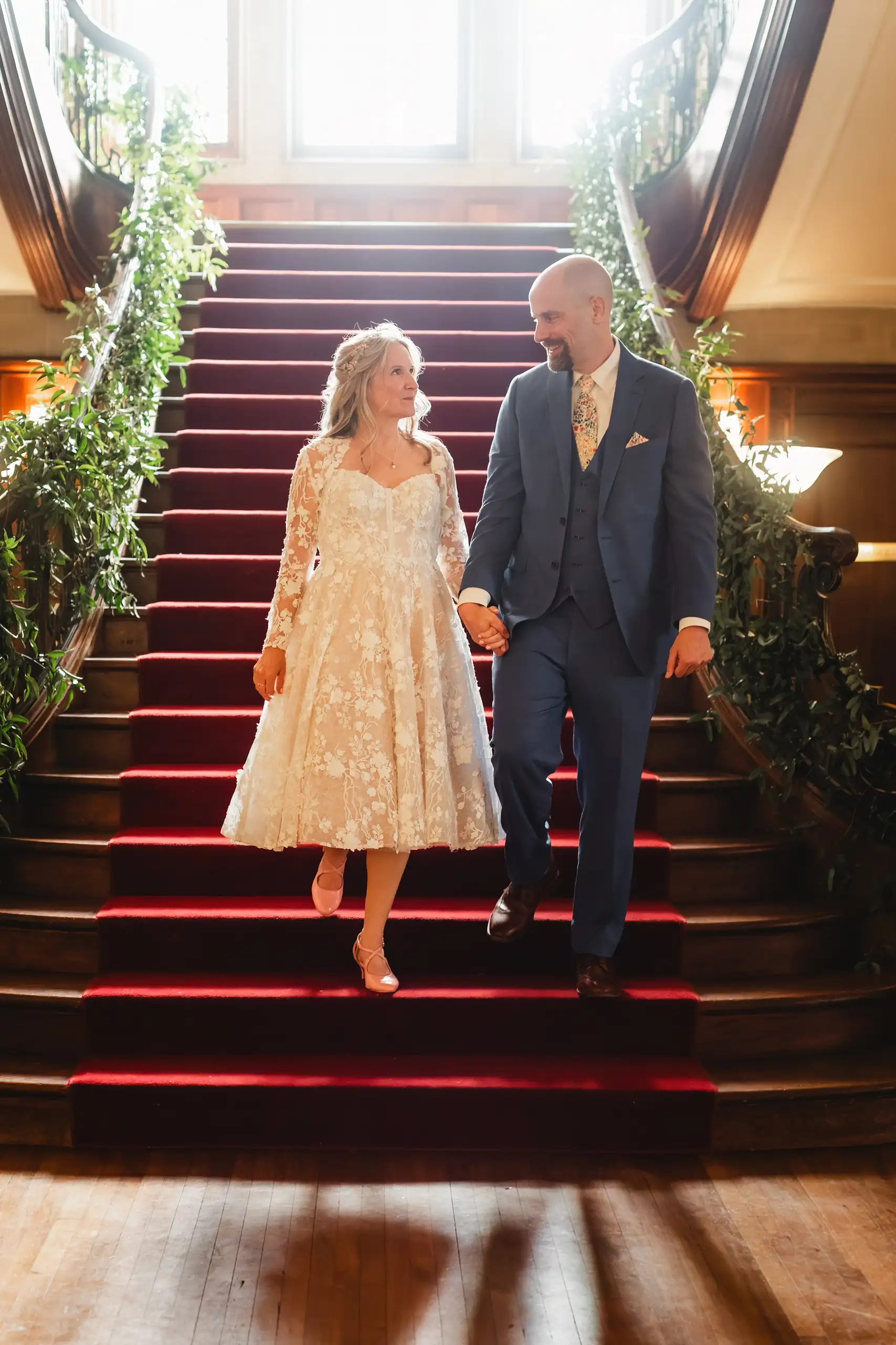 Wedding Formals: the couple coming down the red staircase, at their wedding at Callanwolde Fine Arts Center in Atlanta, GA