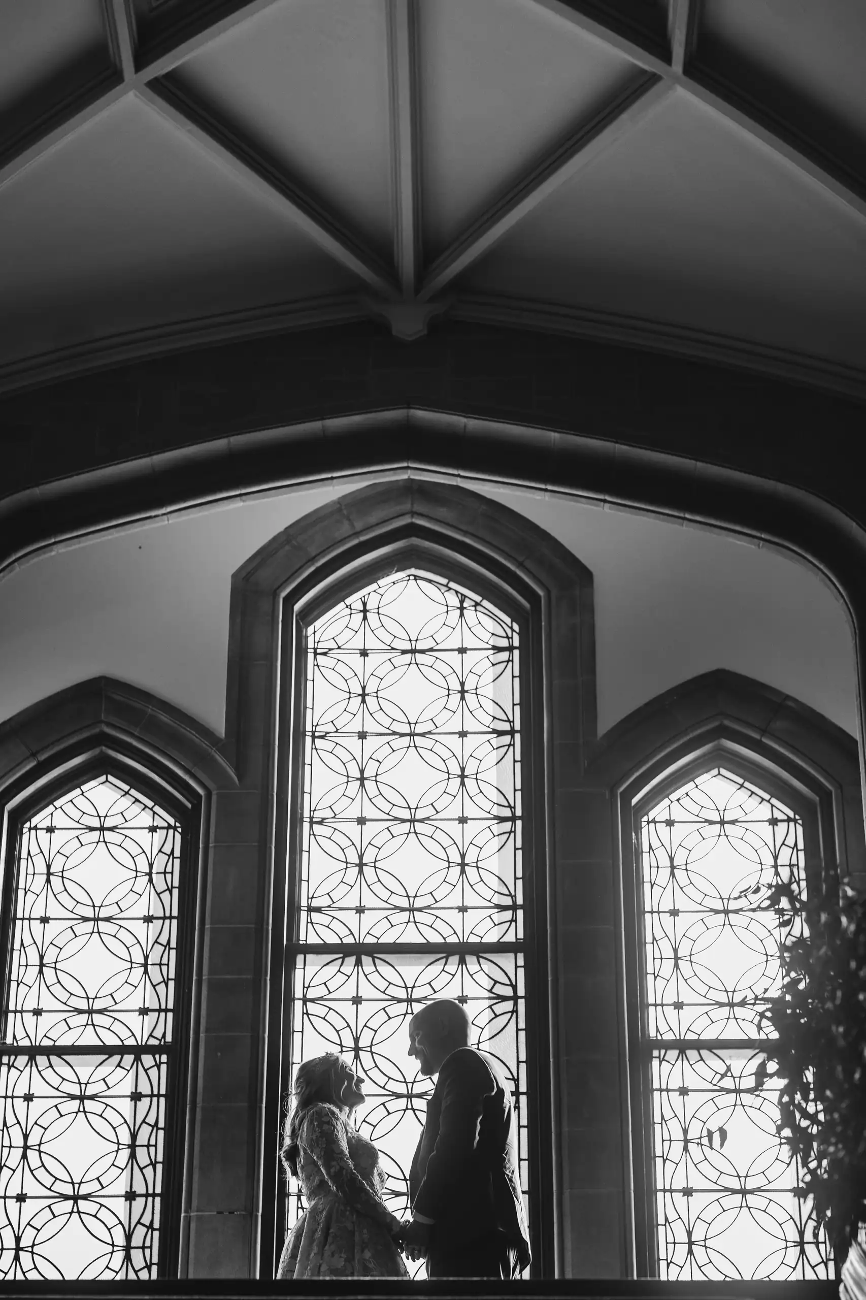 Wedding Formals: the couple silhouetted in the gothic window, at their wedding at Callanwolde Fine Arts Center in Atlanta, GA