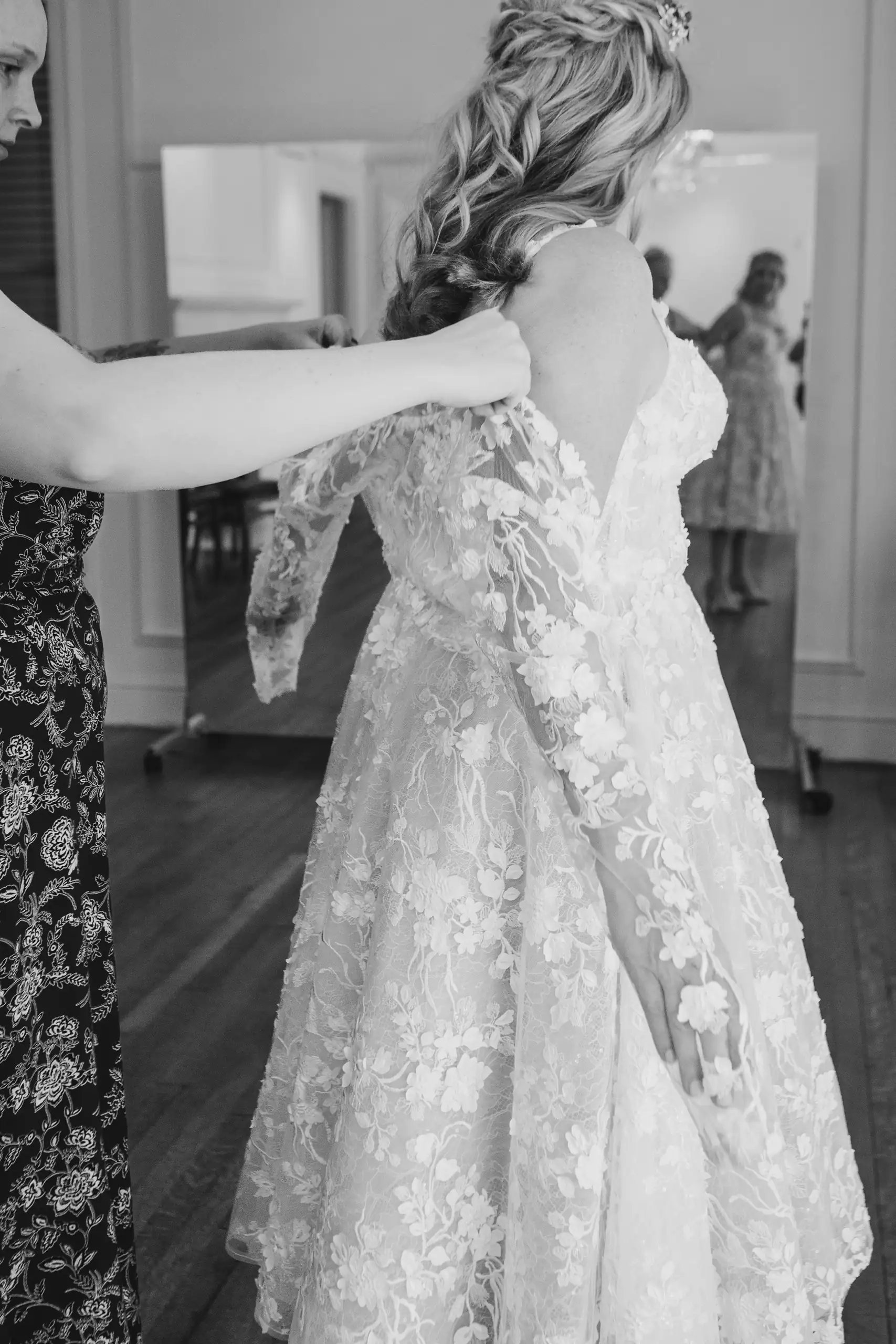 Getting Ready: the back of the lace dress being adjusted, before their wedding at Callanwolde Fine Arts Center in Atlanta, GA