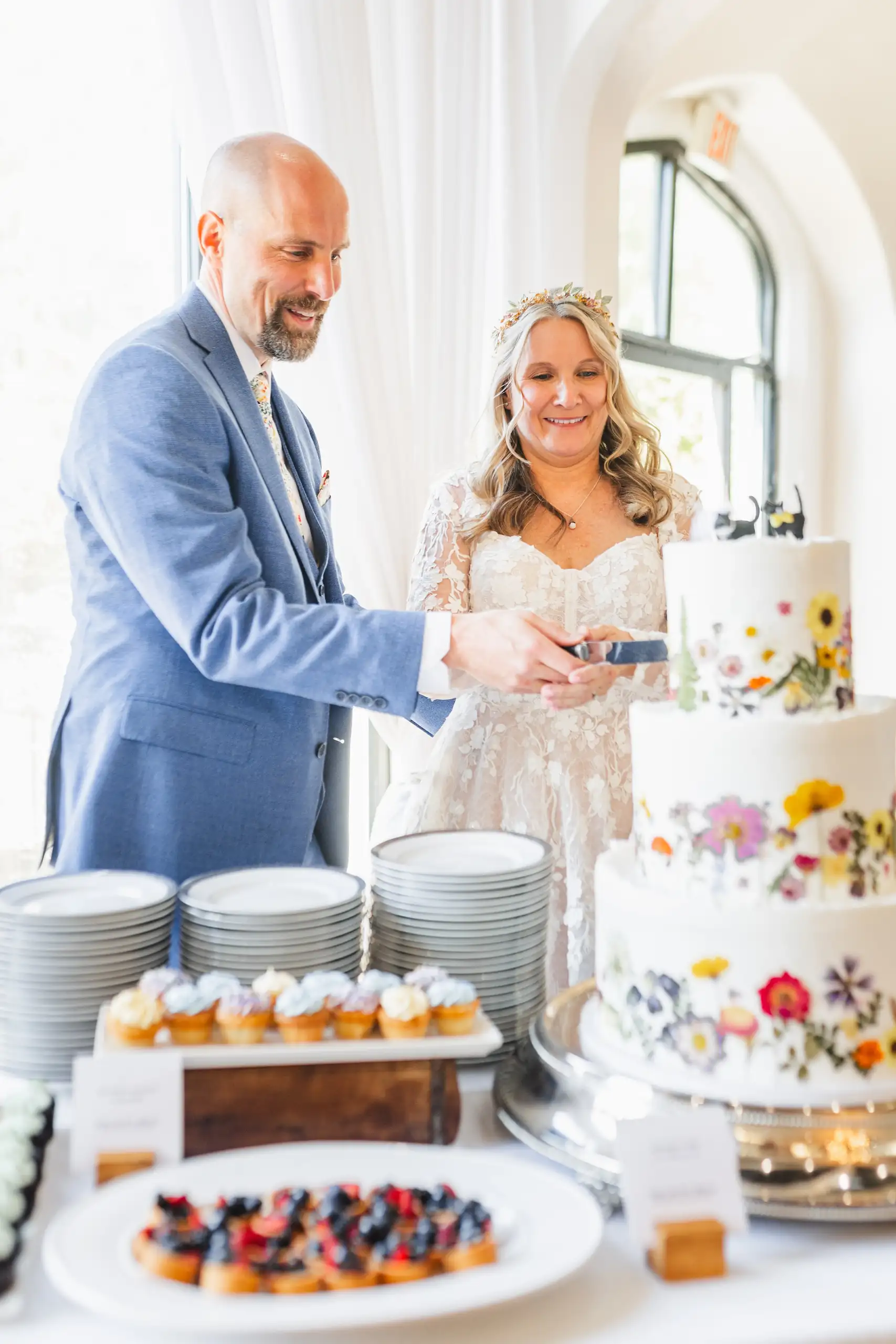 Cake Cutting: the couple cutting the wildflower cake, at their wedding at Callanwolde Fine Arts Center in Atlanta, GA