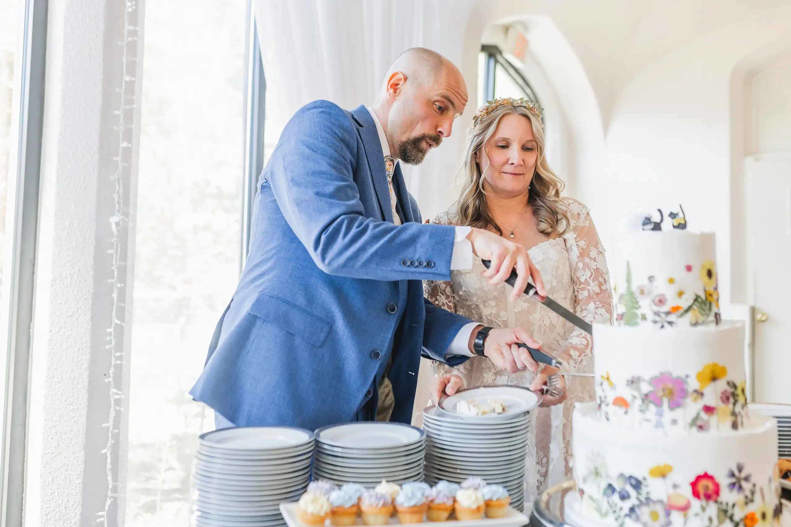 Cake Cutting: the couple serving up the cake, at their wedding at Callanwolde Fine Arts Center in Atlanta, GA