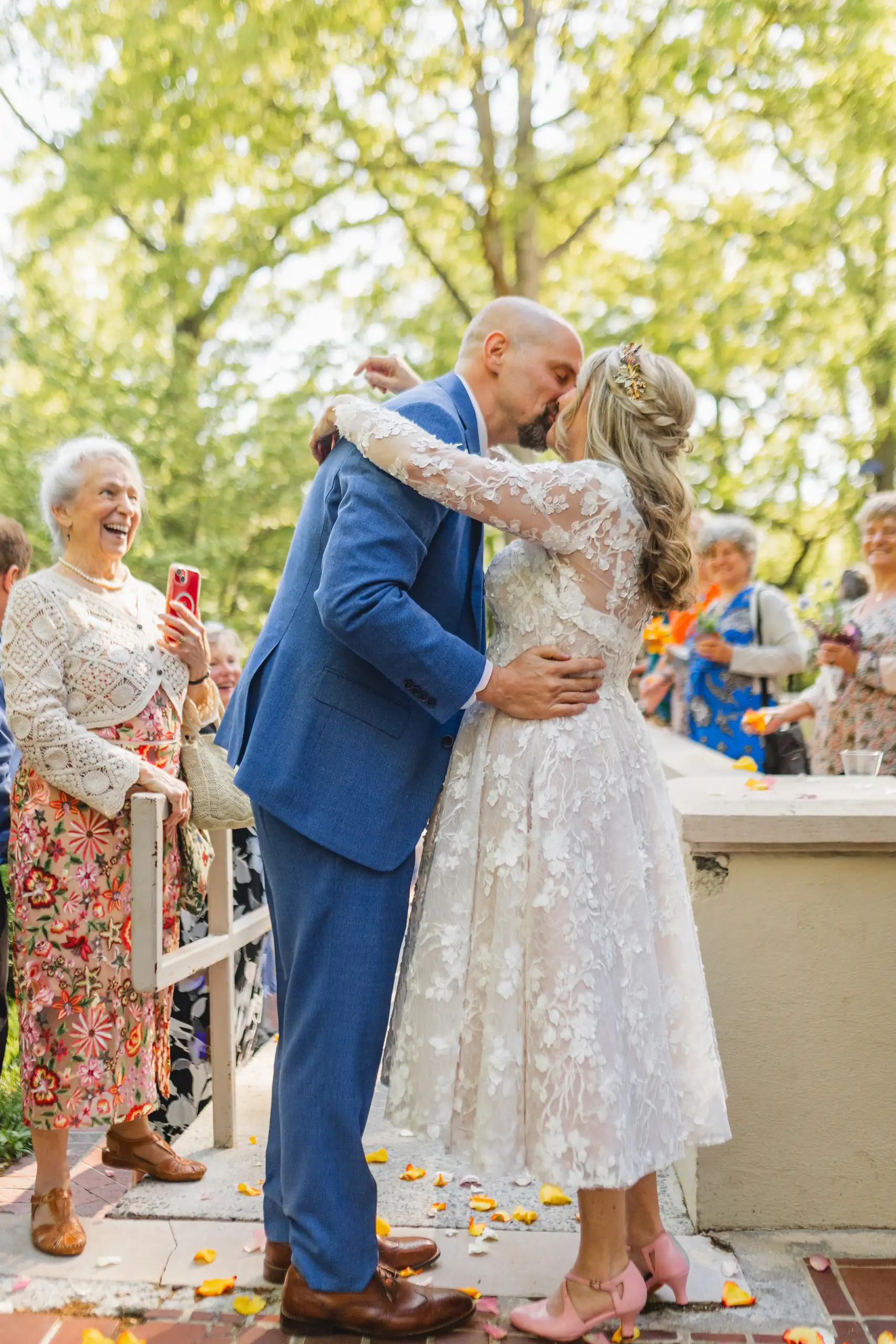 Send-Off: the couple kissing amid the petal toss, at their wedding at Callanwolde Fine Arts Center in Atlanta, GA
