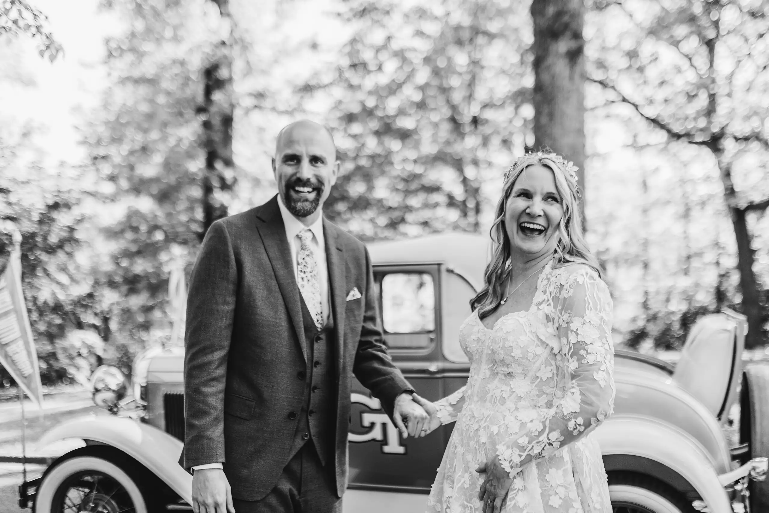 Send-Off: the couple by the Georgia Tech Ramblin' Wreck, in black and white, at their wedding at Callanwolde Fine Arts Center in Atlanta, GA