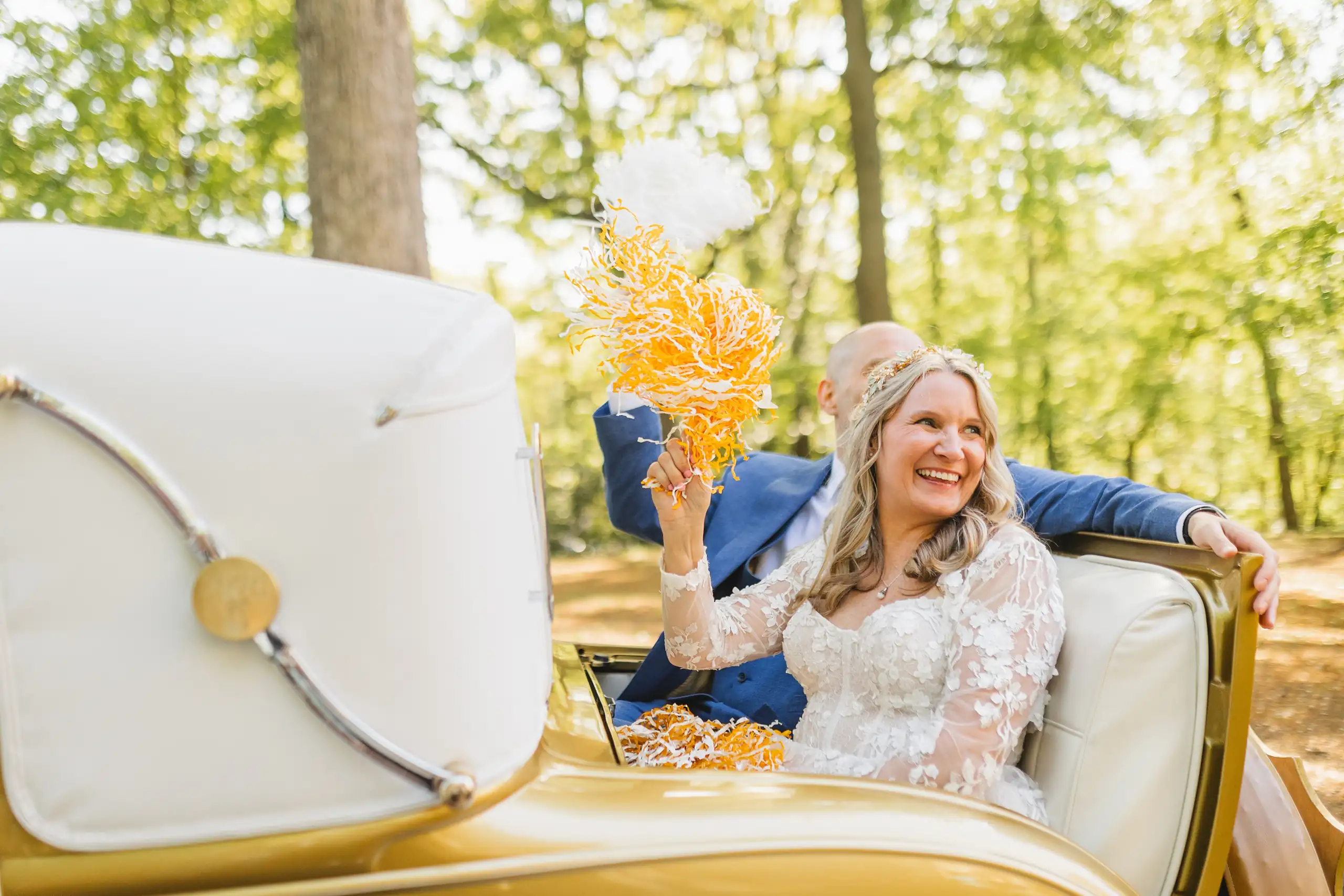 Send-Off: the bride waving her bouquet from the Georgia Tech Ramblin' Wreck, at their wedding at Callanwolde Fine Arts Center in Atlanta, GA