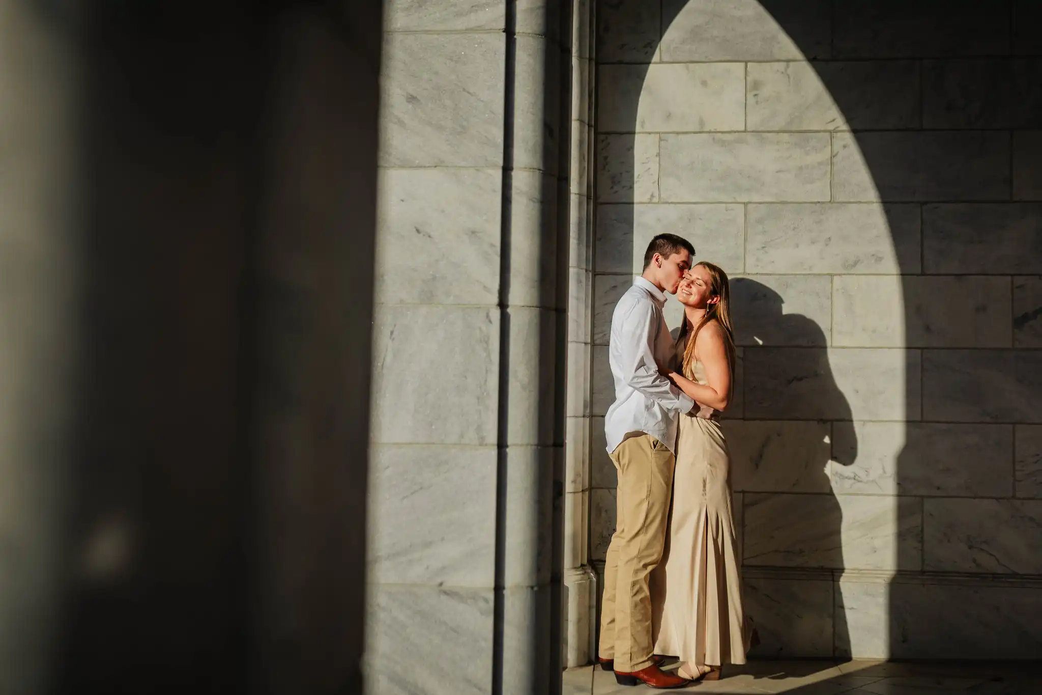 Engagement Portraits: the couple in the shadow of the marble arch, during their engagement session at the Millennium Gate in Atlanta, GA