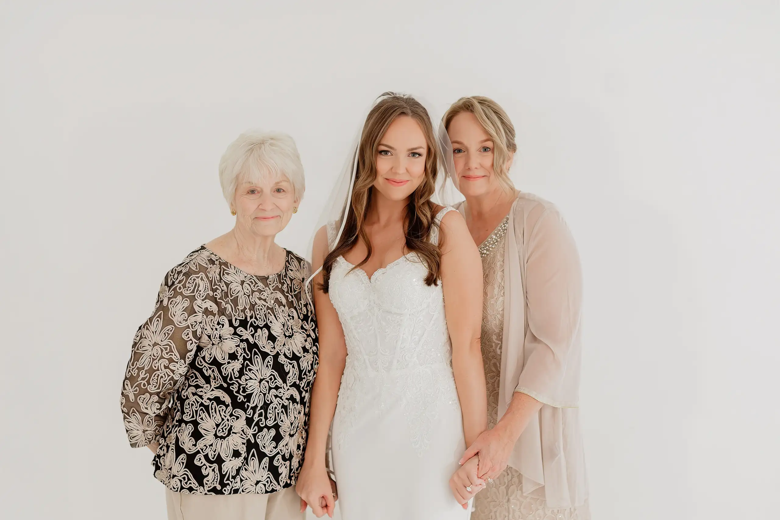 Bridal Portraits: the bride between her mother and grandmother, during her bridal portrait session