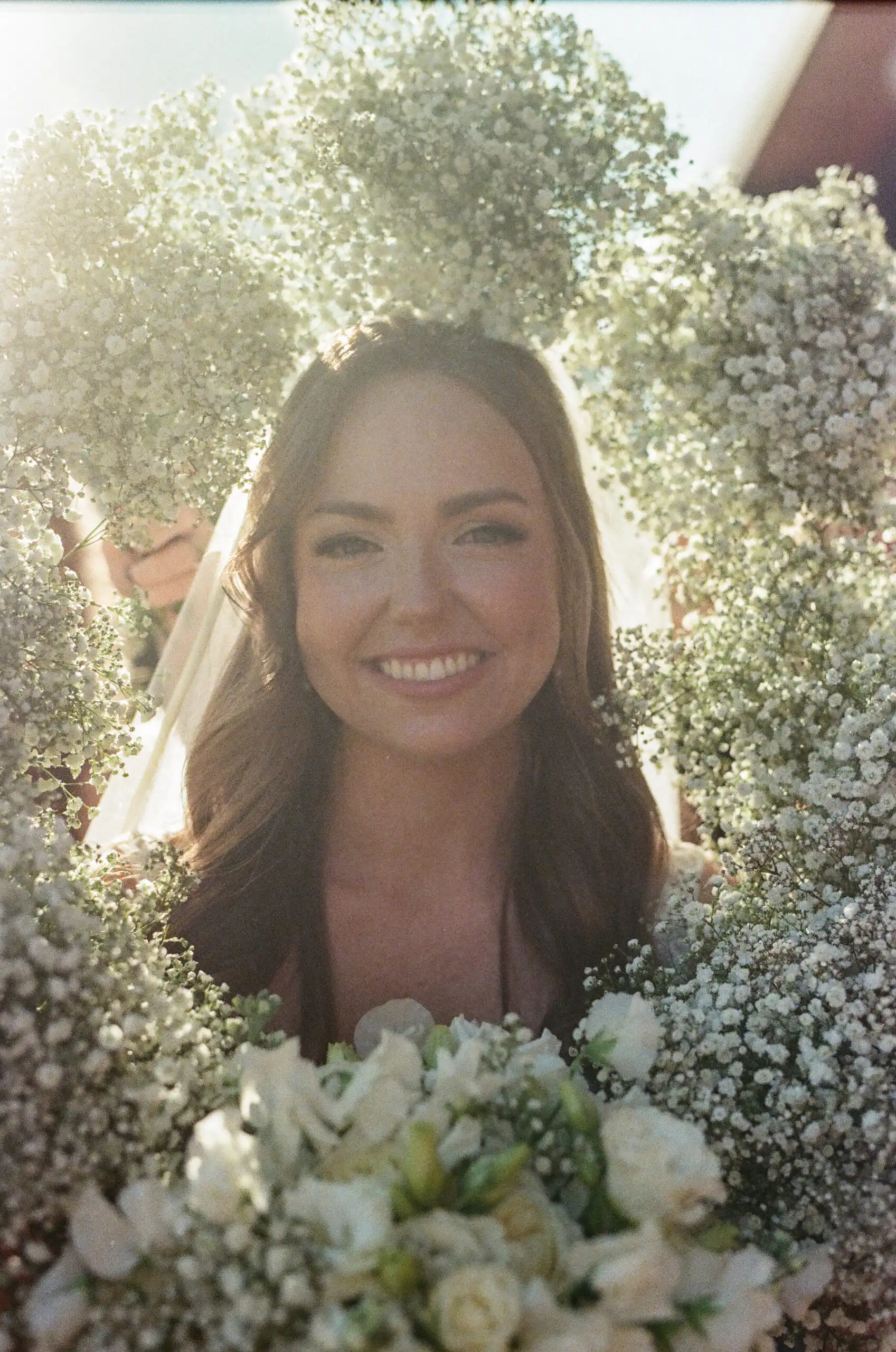 Bride framed by baby's breath on her wedding day, shot on 35mm film
