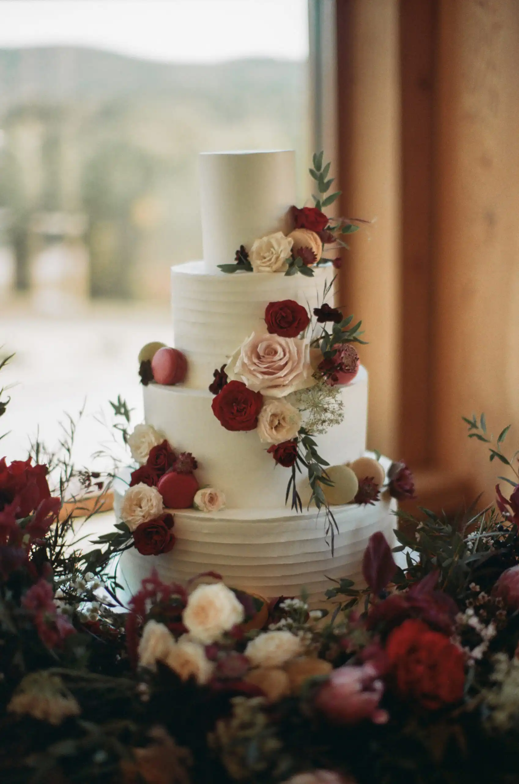 Four-tier wedding cake with red and blush roses, shot on 35mm film at The Venue at Sharp Mountain in North Georgia