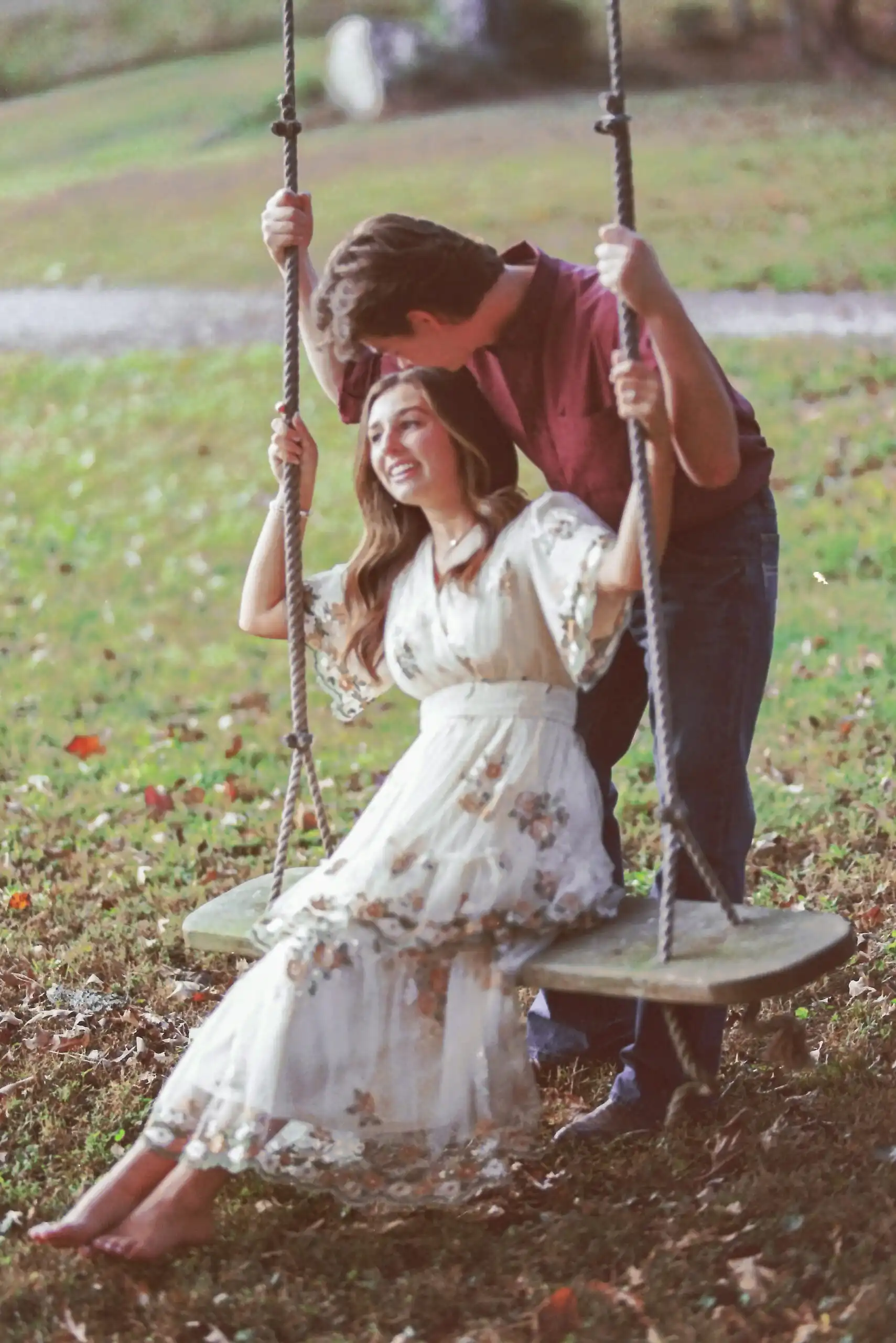 Couple on a tree swing at their engagement session, shot on 35mm film in Canton, GA