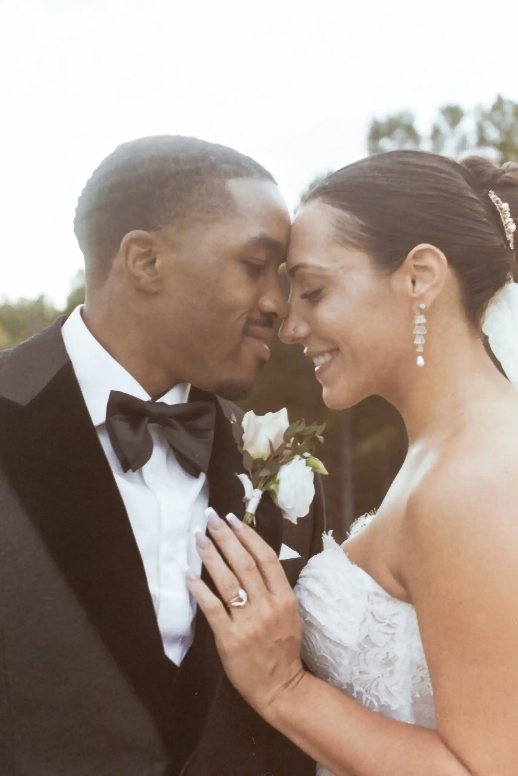 Bride and groom forehead to forehead at their wedding, shot on 35mm film