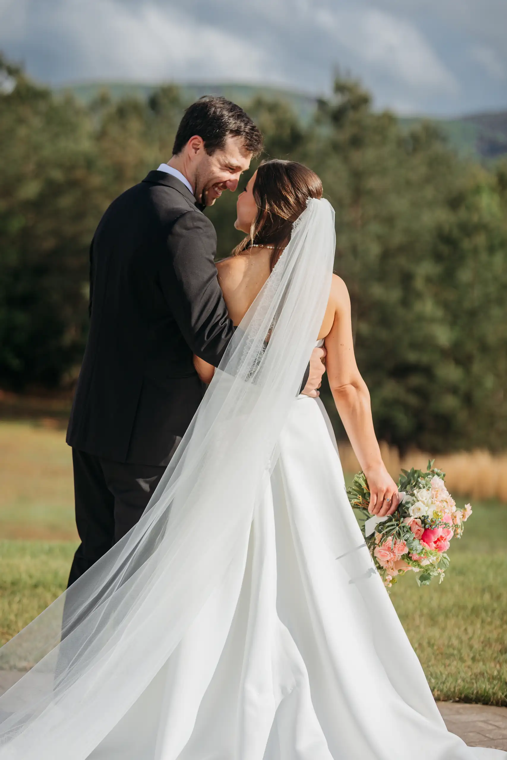 Wedding Formals: the two of them together on the lawn, veil across her back, at their wedding at The Venue at Sharp Mountain in Jasper, GA