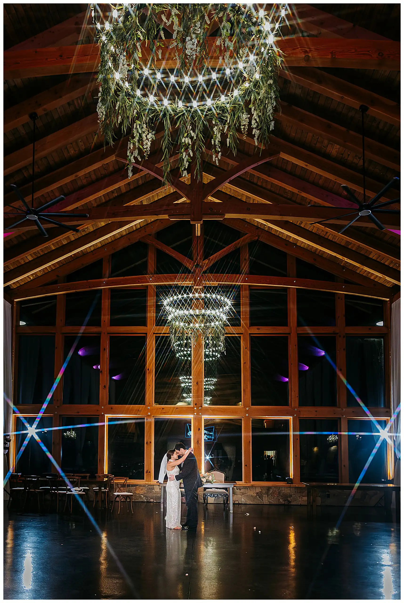 Wedding Reception: the couple alone on the floor beneath the hanging greenery, at their wedding at The Venue at Sharp Mountain in Jasper, GA