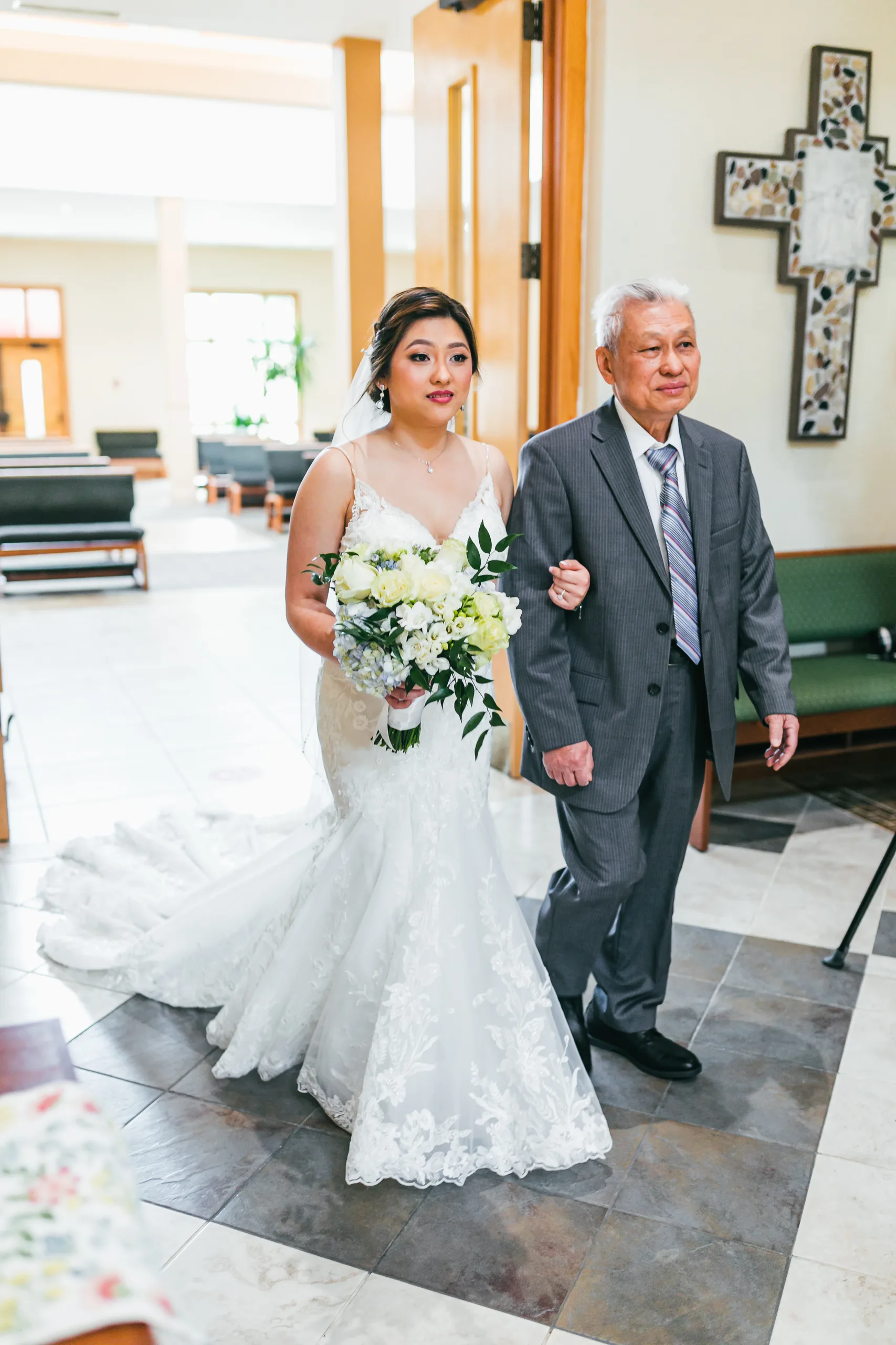Wedding Ceremony: the bride walking in with her father at their wedding at Holy Cross Catholic Church in Atlanta, GA