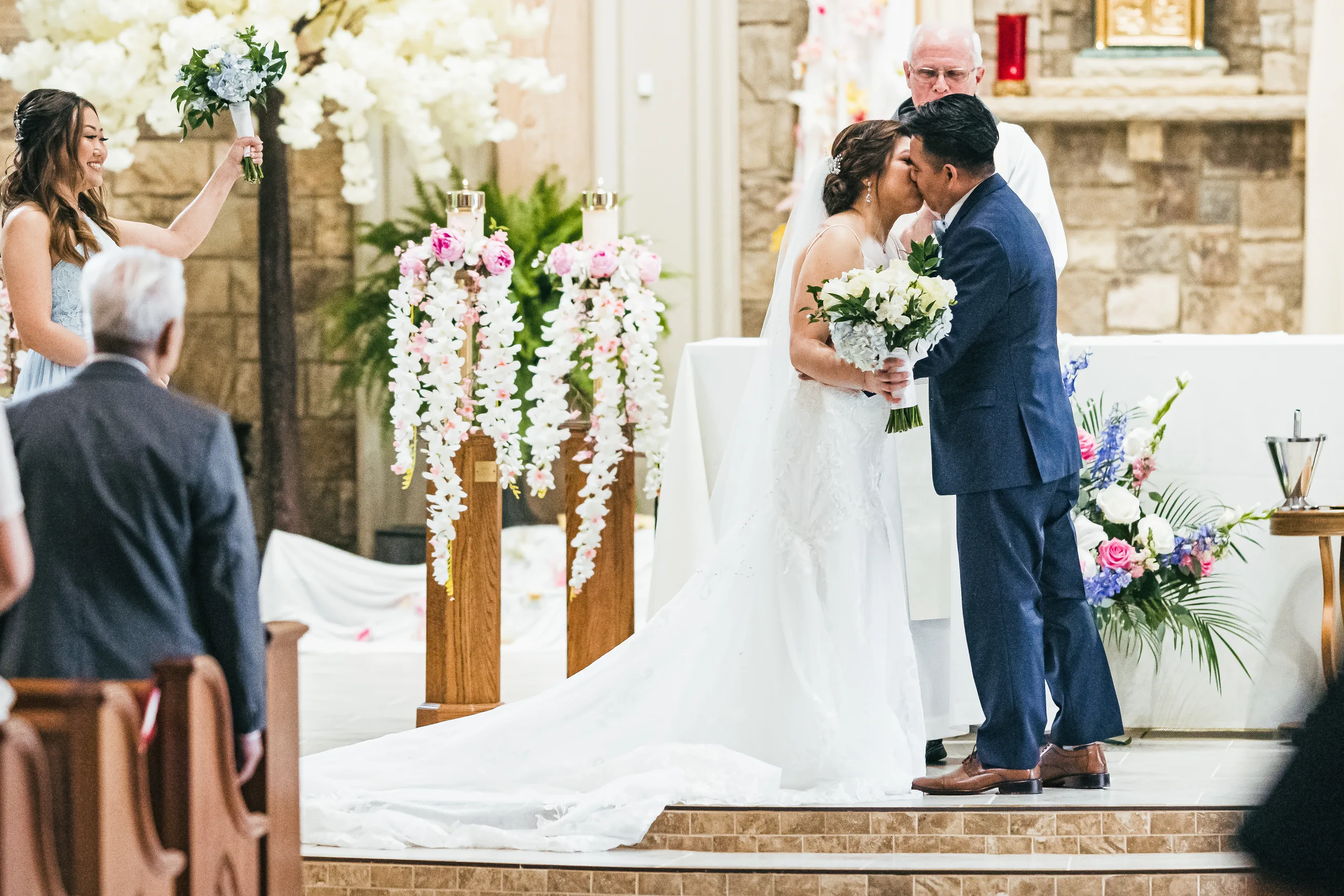 Wedding Ceremony: the first kiss at the altar at their wedding at Holy Cross Catholic Church in Atlanta, GA