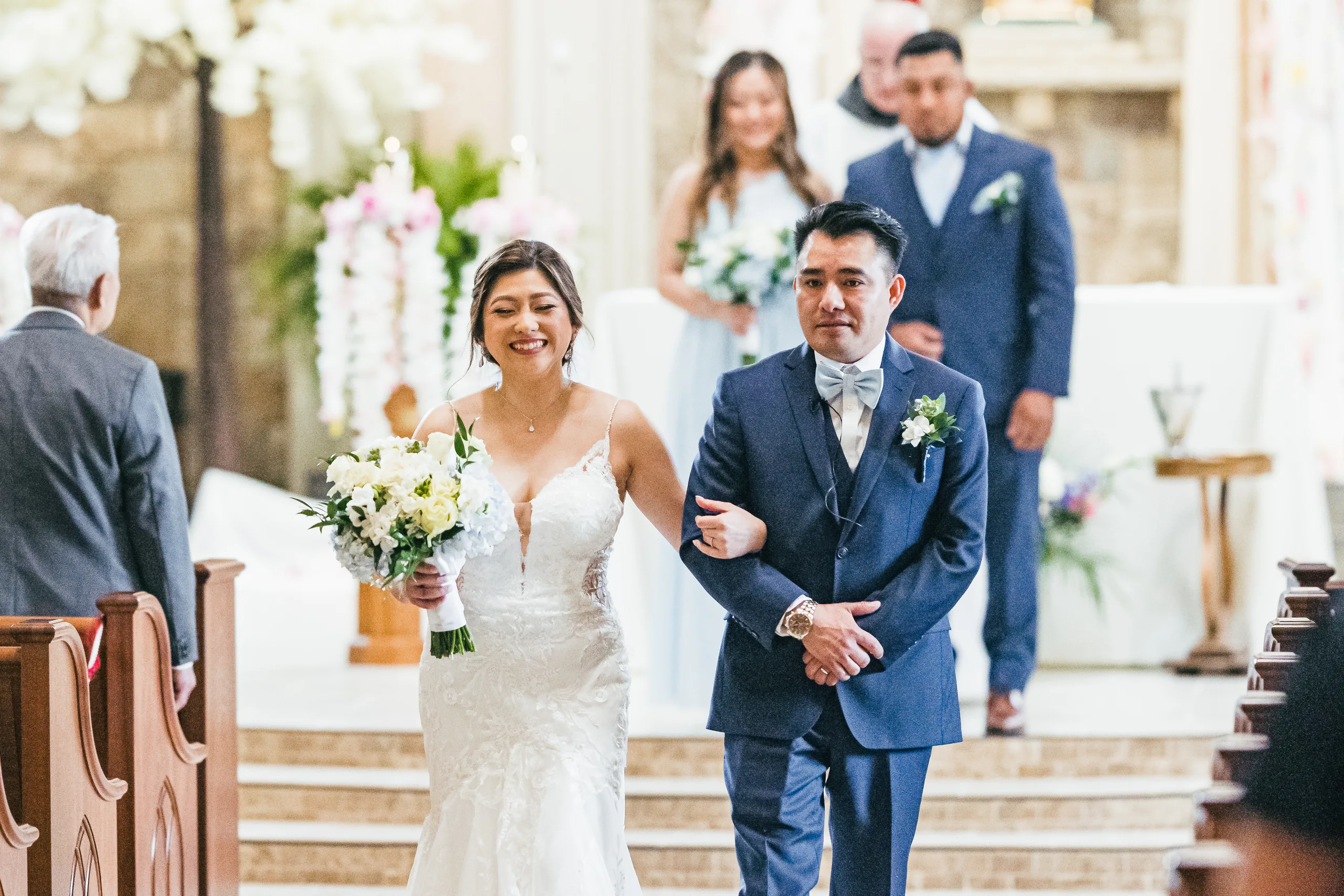 Wedding Ceremony: walking back up the aisle as husband and wife at their wedding at Holy Cross Catholic Church in Atlanta, GA