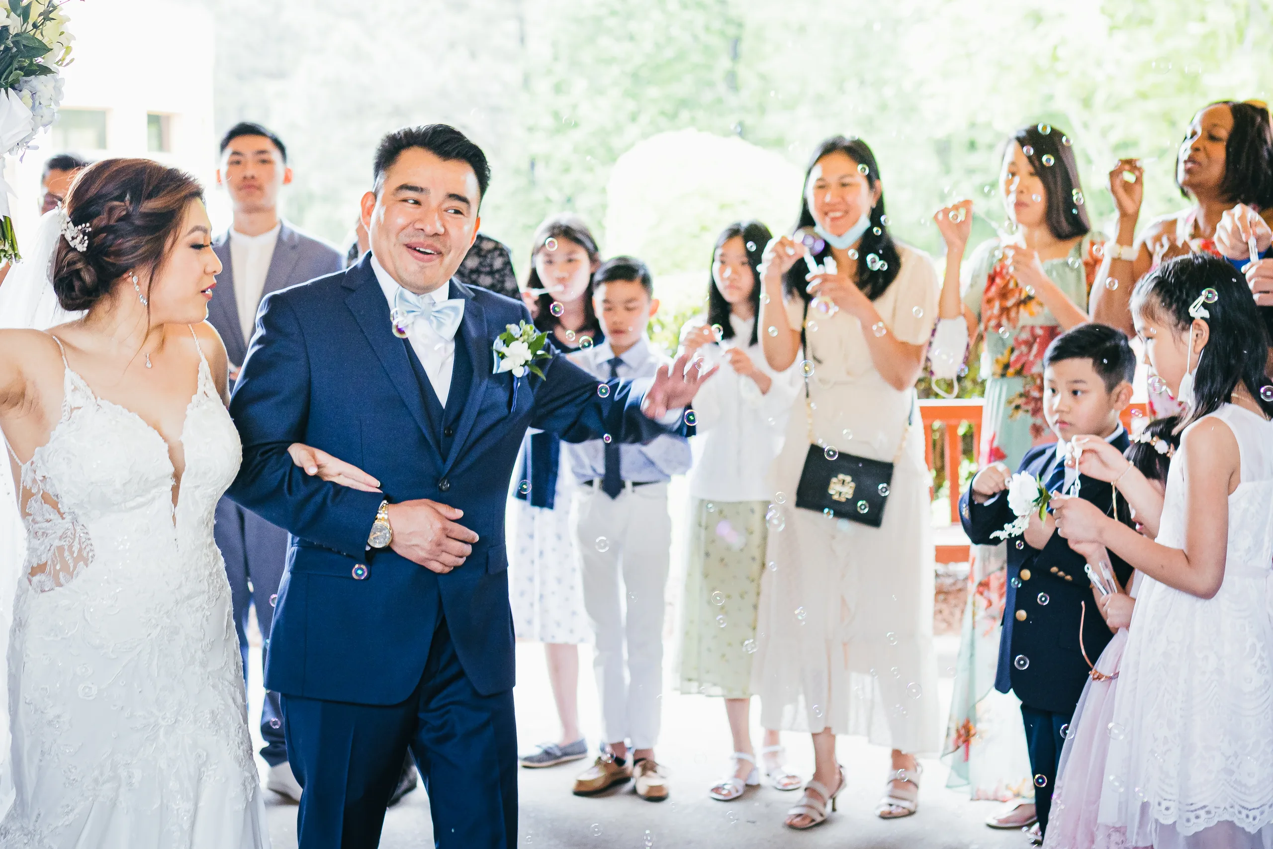 Wedding Ceremony: walking out past their cheering guests at their wedding at Holy Cross Catholic Church in Atlanta, GA