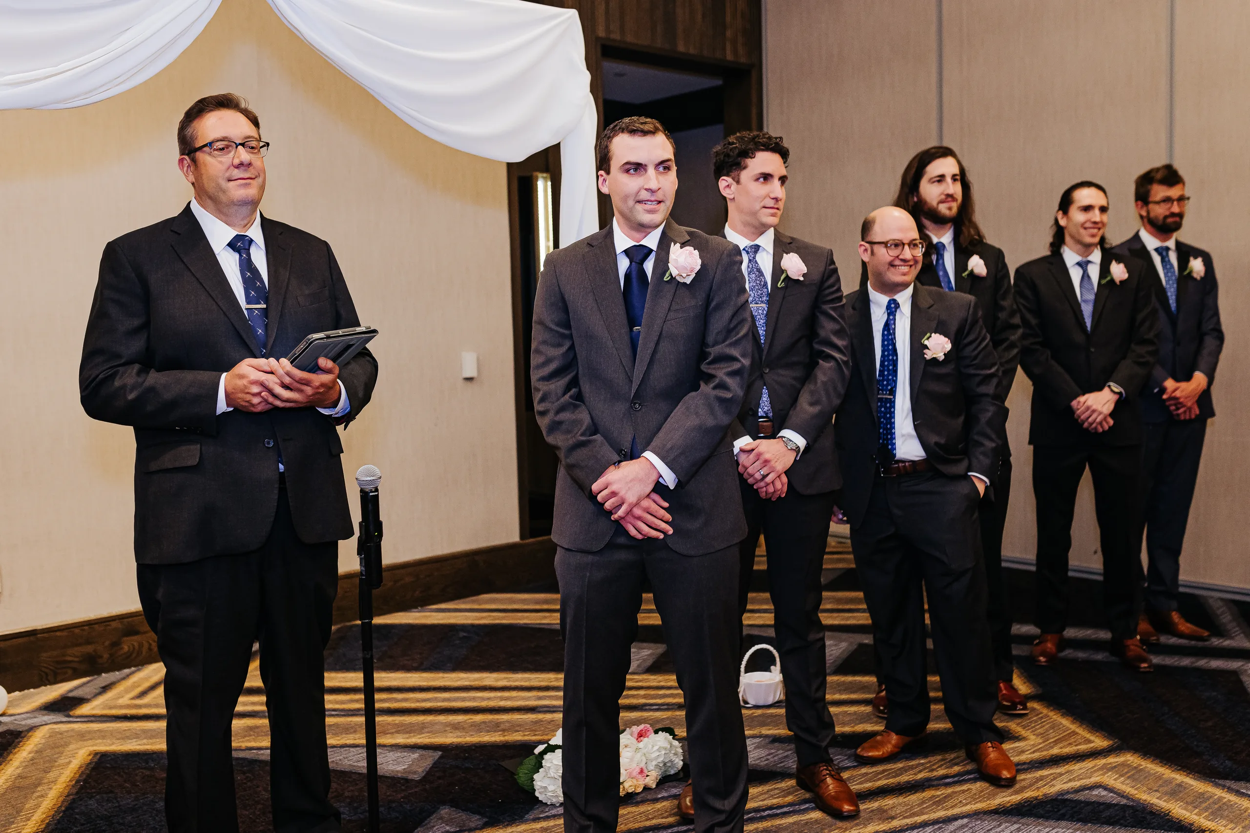 Wedding Ceremony: the groom and groomsmen waiting with the officiant at their wedding at the Omni Hotel at The Battery in Atlanta, GA
