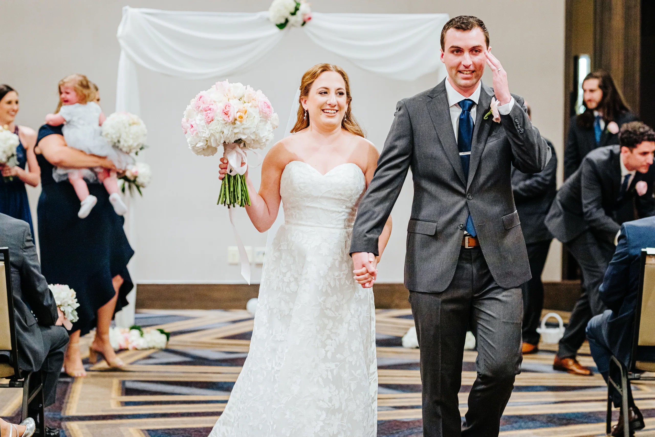 Wedding Ceremony: walking back up the aisle as husband and wife at their wedding at the Omni Hotel at The Battery in Atlanta, GA