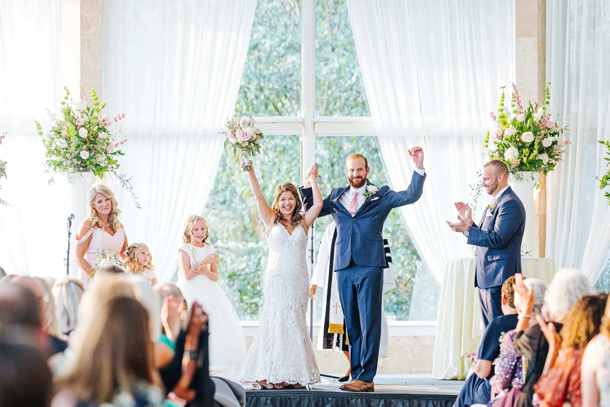Wedding Ceremony: their arms thrown up in the air after the kiss, at their wedding at The Piedmont Room in Atlanta, GA