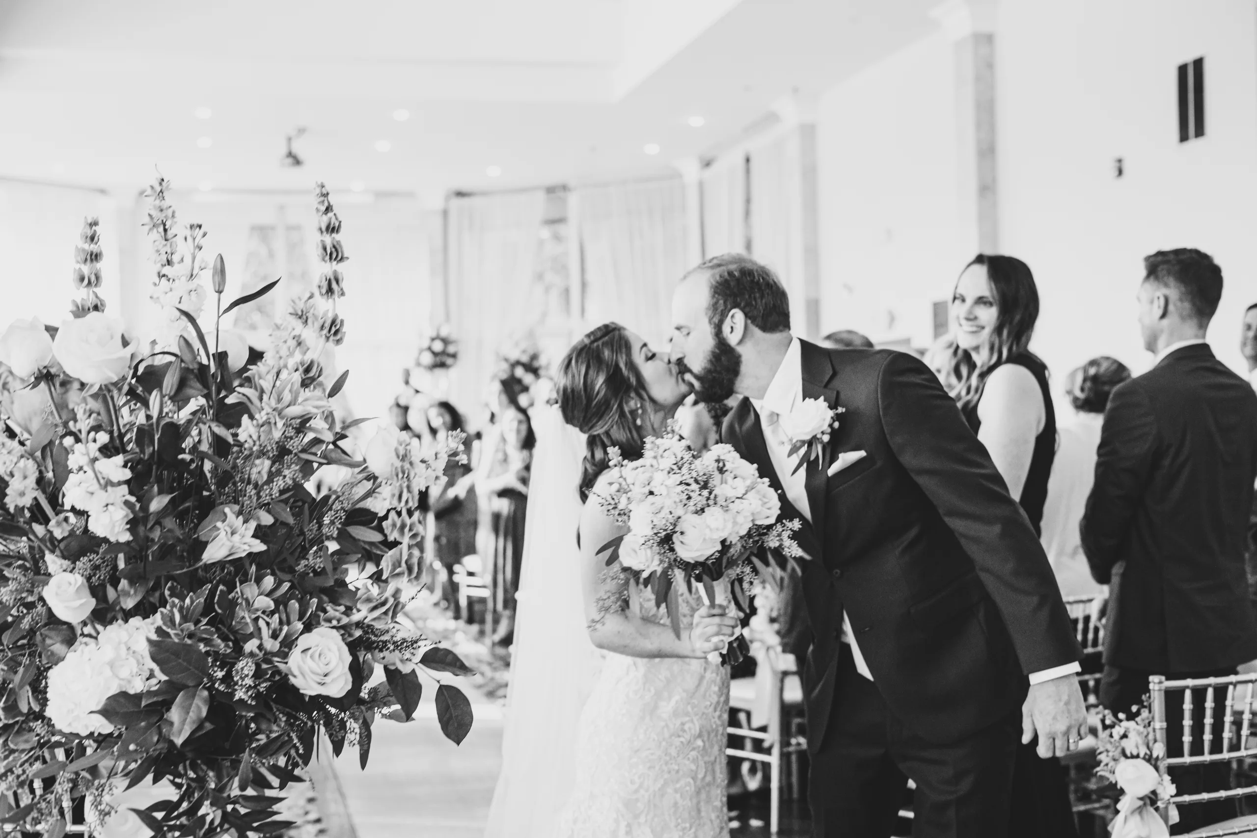 Wedding Ceremony: a kiss on the way back up the aisle, in black and white, at their wedding at The Piedmont Room in Atlanta, GA