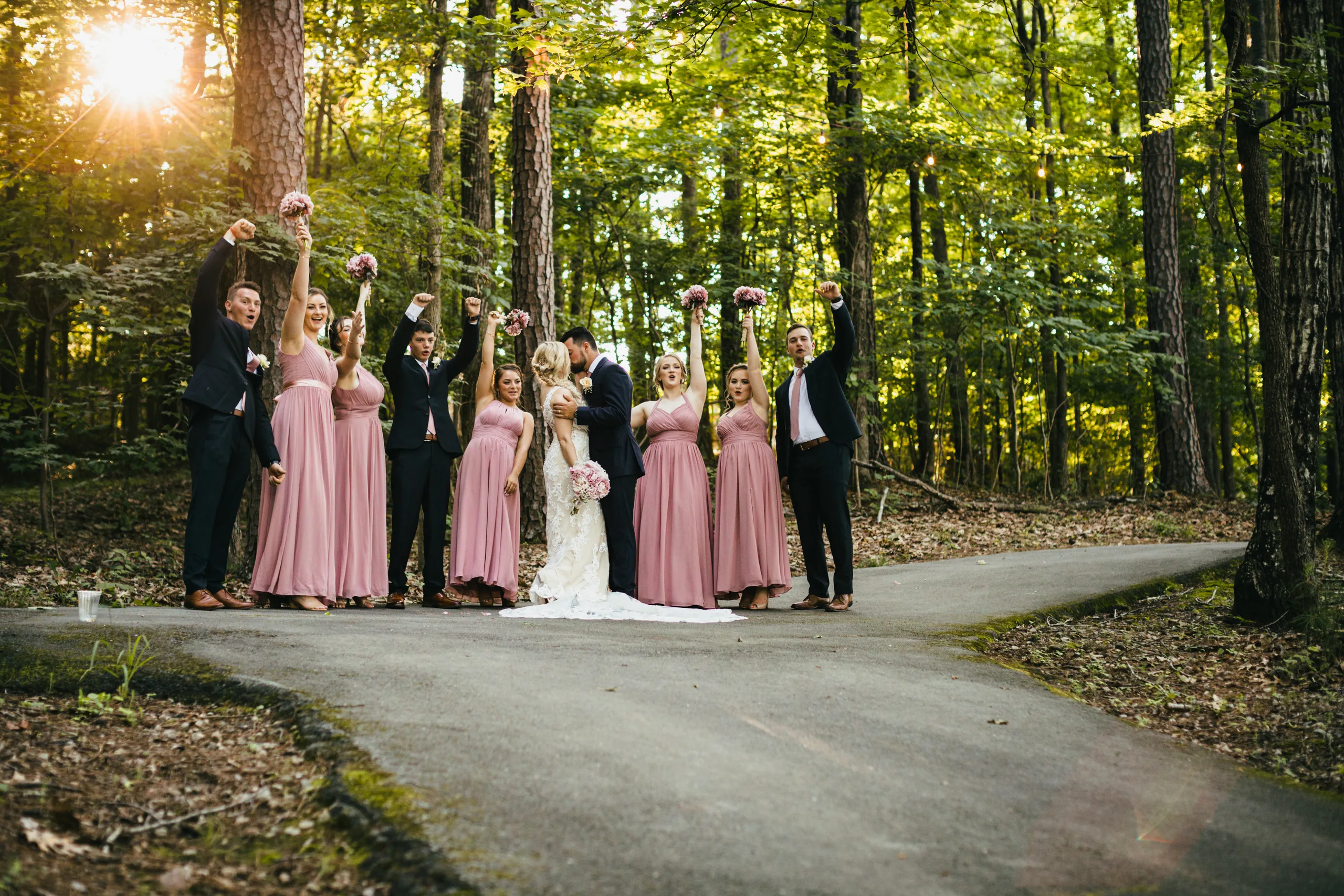 Wedding Party: everyone cheering on the path through the woods, at their wedding at Atlanta Evergreen Lakeside Resort in Stone Mountain, GA