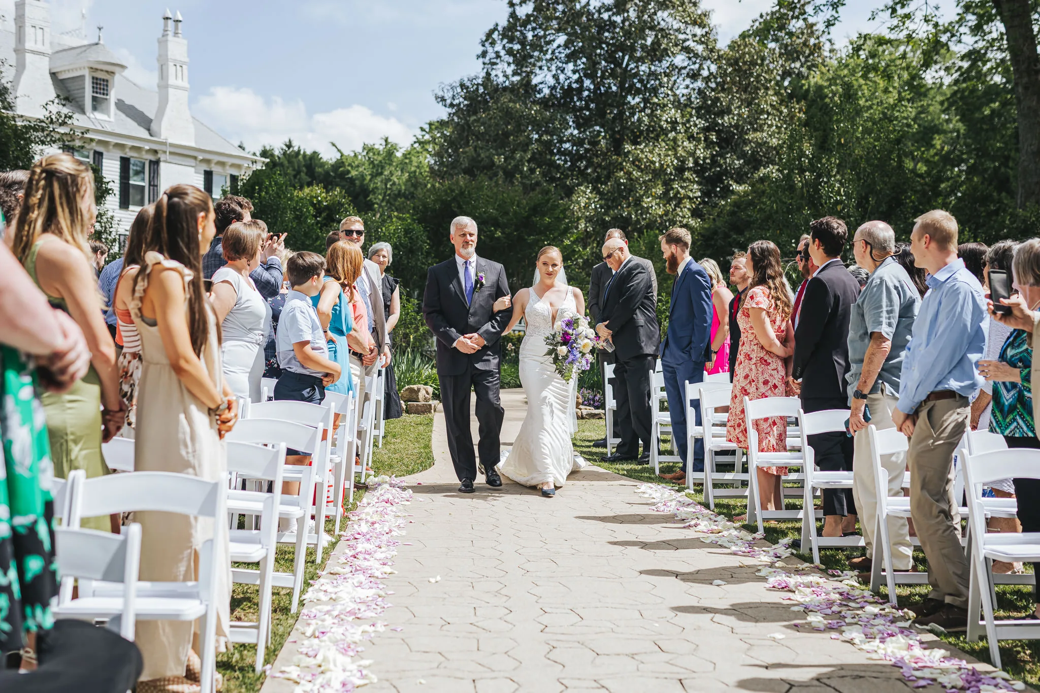 Wedding Ceremony: the bride walking down the aisle through the garden, at their wedding at The Wildflower 301 in Greensboro, GA