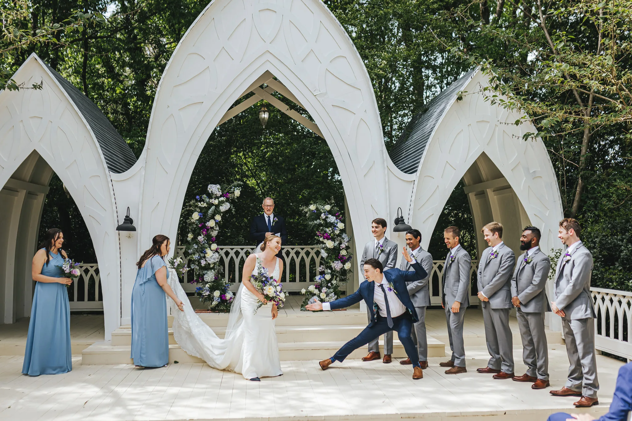 Wedding Ceremony: a groomsman lunging after the kiss, at their wedding at The Wildflower 301 in Greensboro, GA