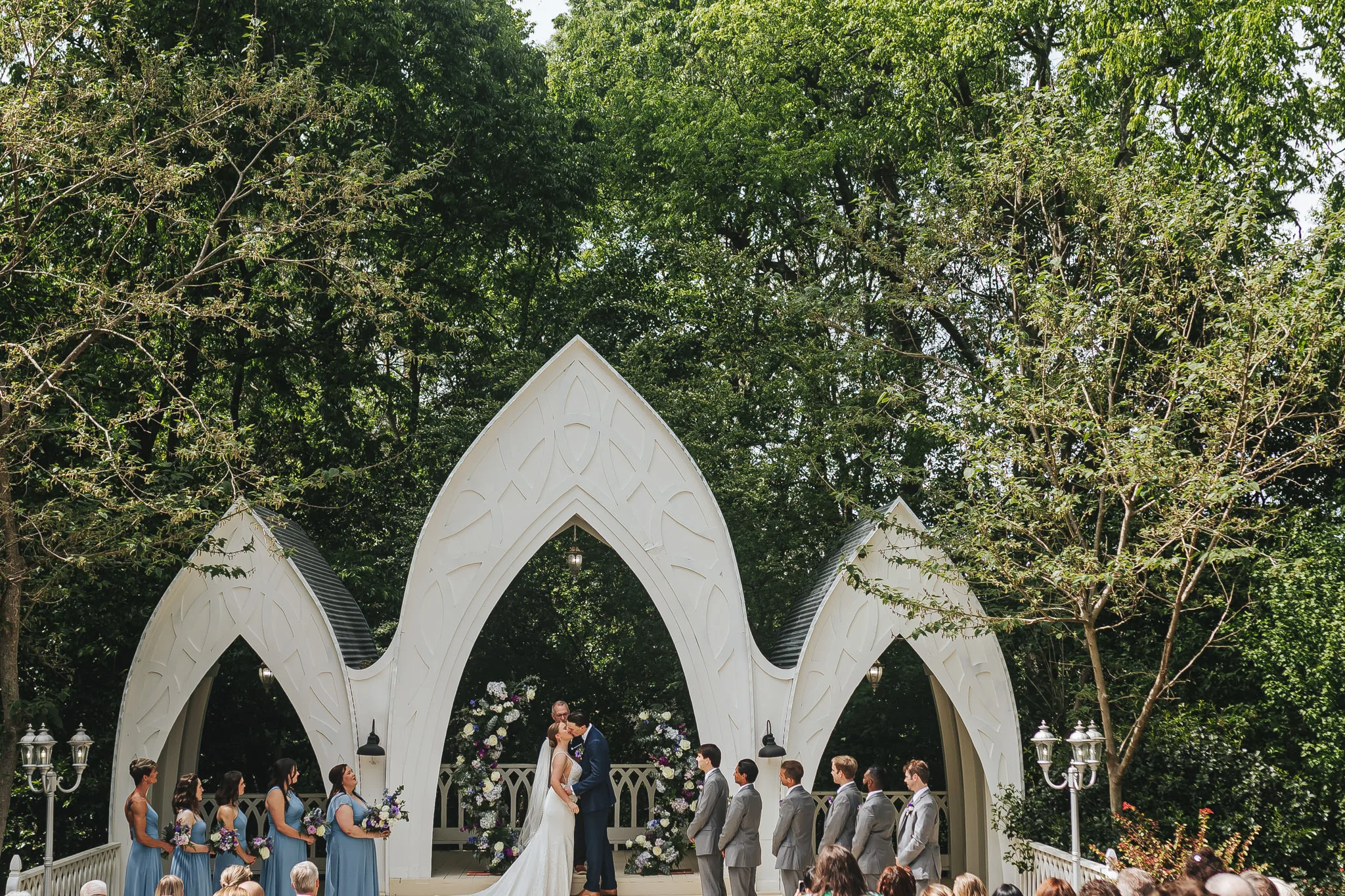 Wedding Ceremony: the ceremony under the white arches in the trees, at their wedding at The Wildflower 301 in Greensboro, GA