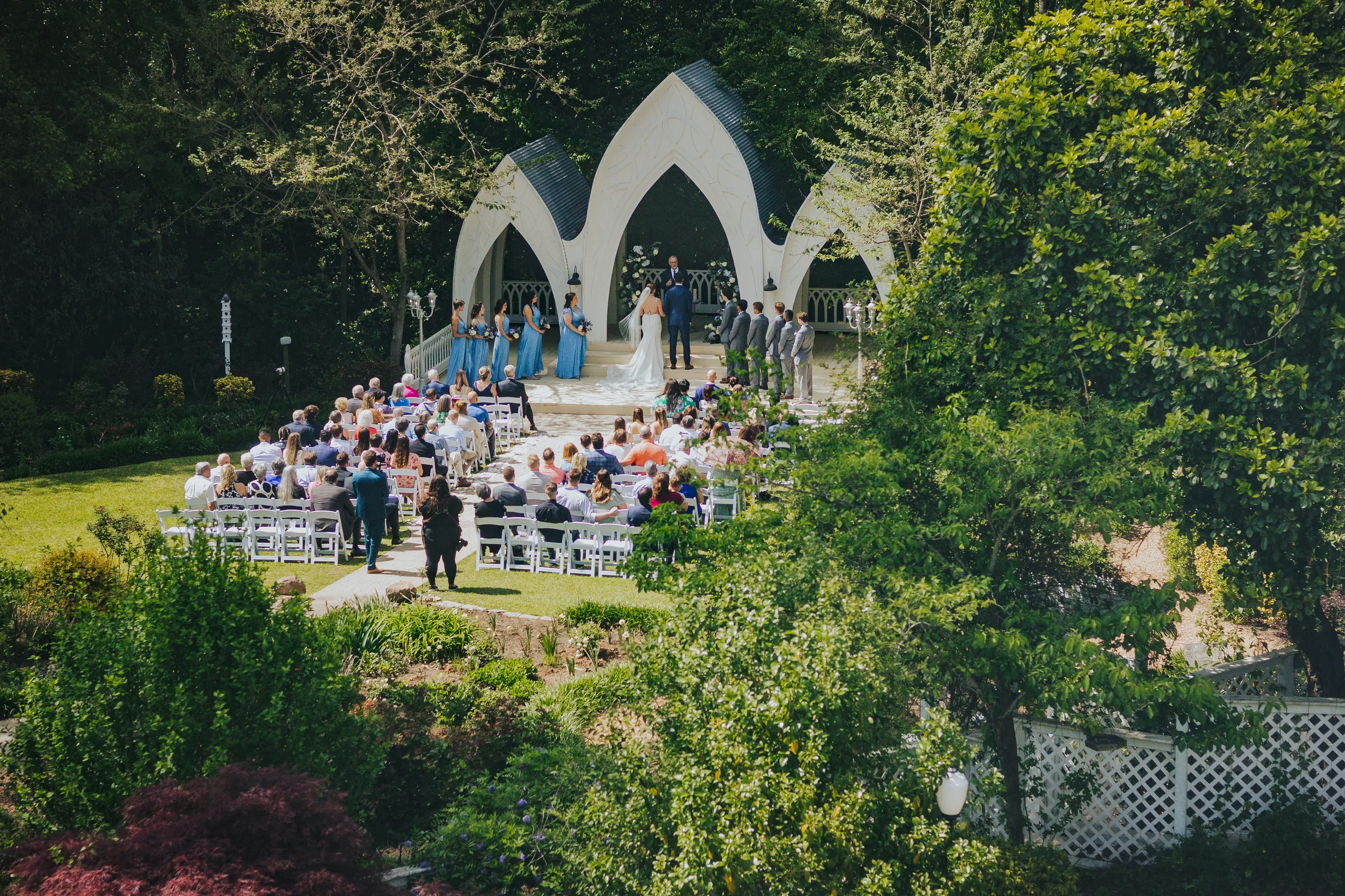 Wedding Ceremony: the ceremony at the chapel seen from above the gardens, at their wedding at The Wildflower 301 in Greensboro, GA
