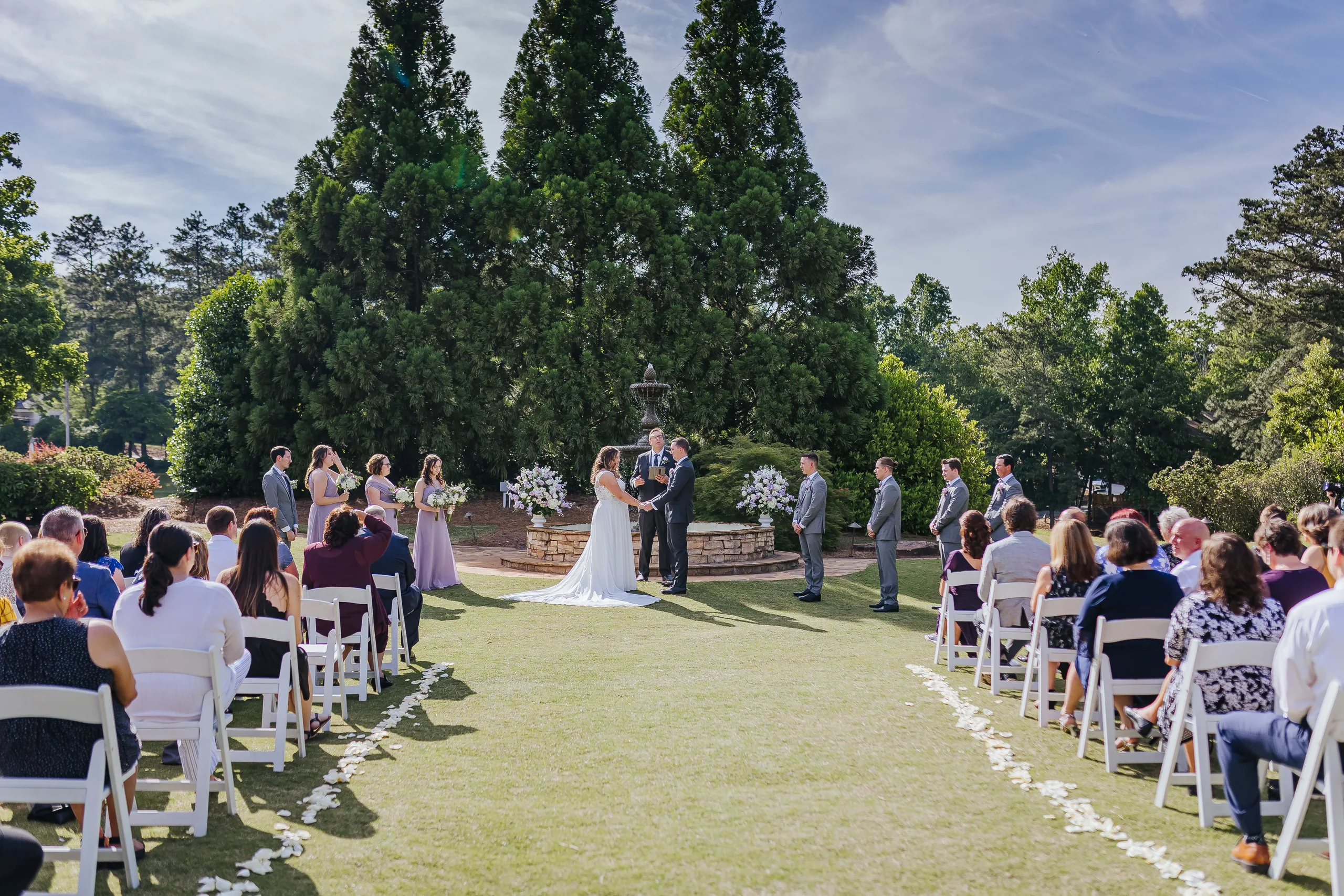 Wedding Ceremony: the ceremony on the lawn in front of the fountain at their wedding at the Country Club of Roswell in Roswell, GA